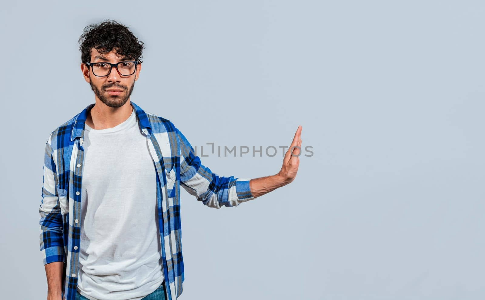 Displeased young man rejecting with rejection gesture, throw palms isolated. Displeased person with rejection gesture isolated, pulls palms in rejection, frowns in disgust