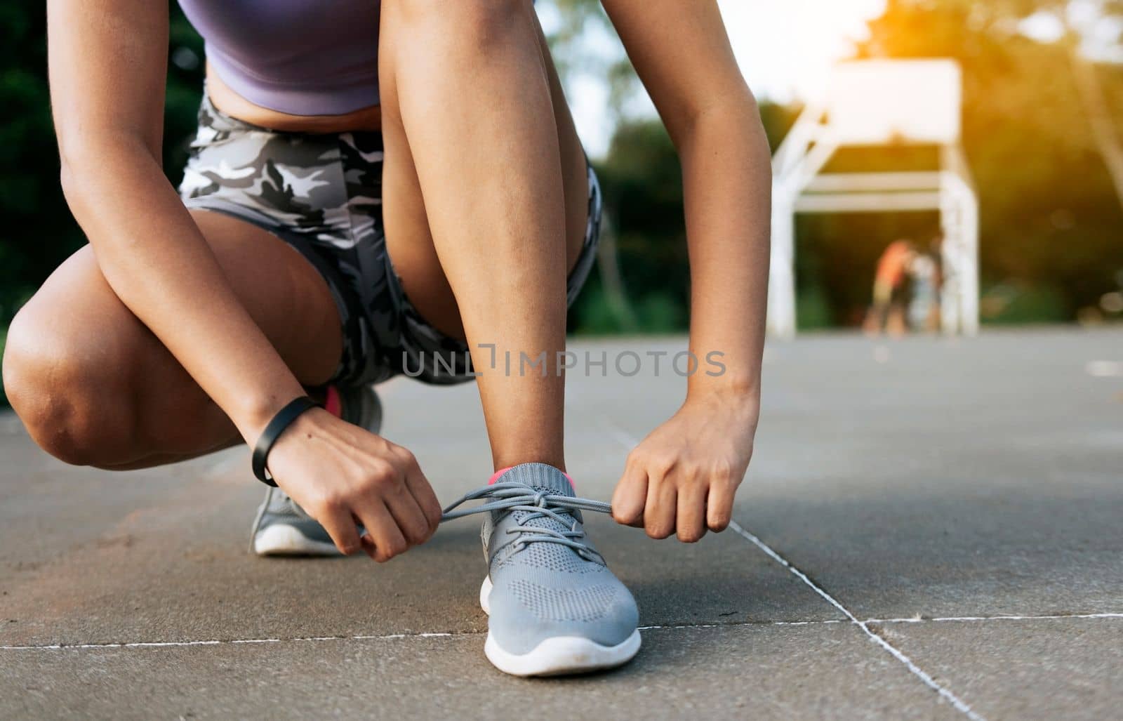 Sport girl tying her shoe laces in a park. Runner girl tying her running shoes in a park with space for text, Close-up of sporty woman tying her shoes with copy space