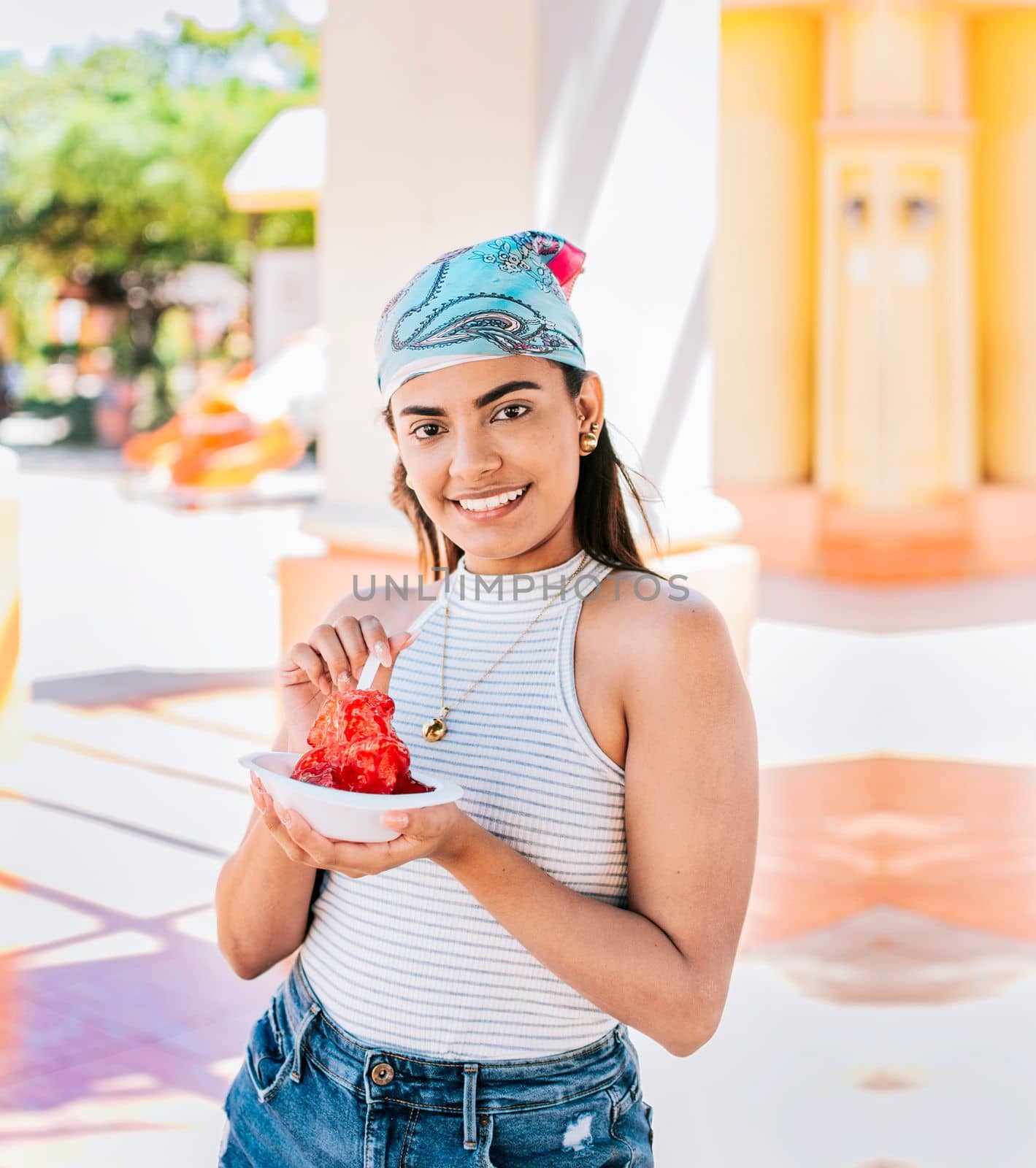 Portrait of smiling girl holding shaved ice in the street. Young woman holding a cup of shaved ice on the street. Concept of a girl with a Nicaraguan raspado. ICE SHAVING from Nagarote by isaiphoto