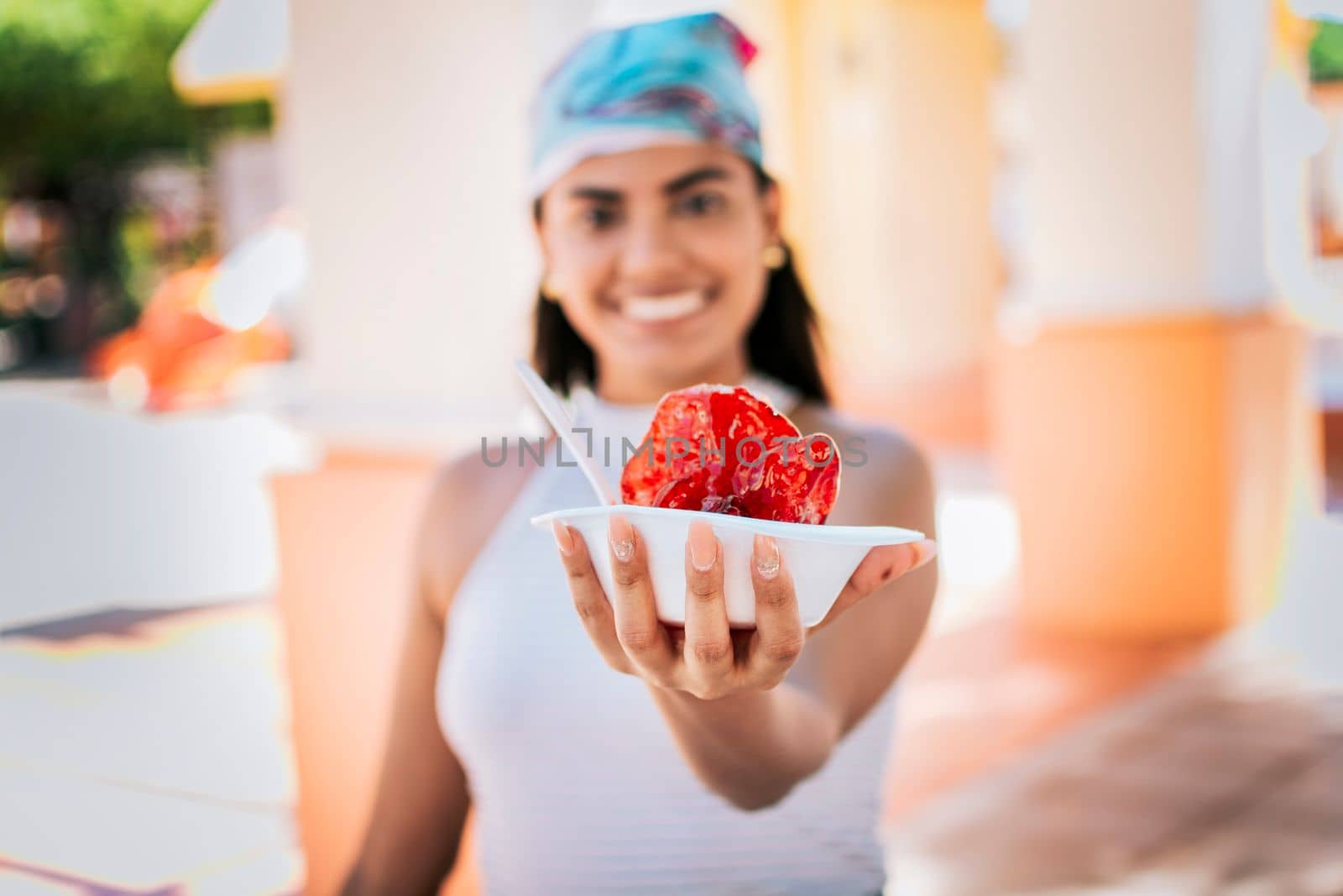 Close up of young woman holding a shaved ice in the street. Concept of a girl with a Nicaraguan raspado, Raspado of Nagarote. Smiling girl holding shaved ice on the street