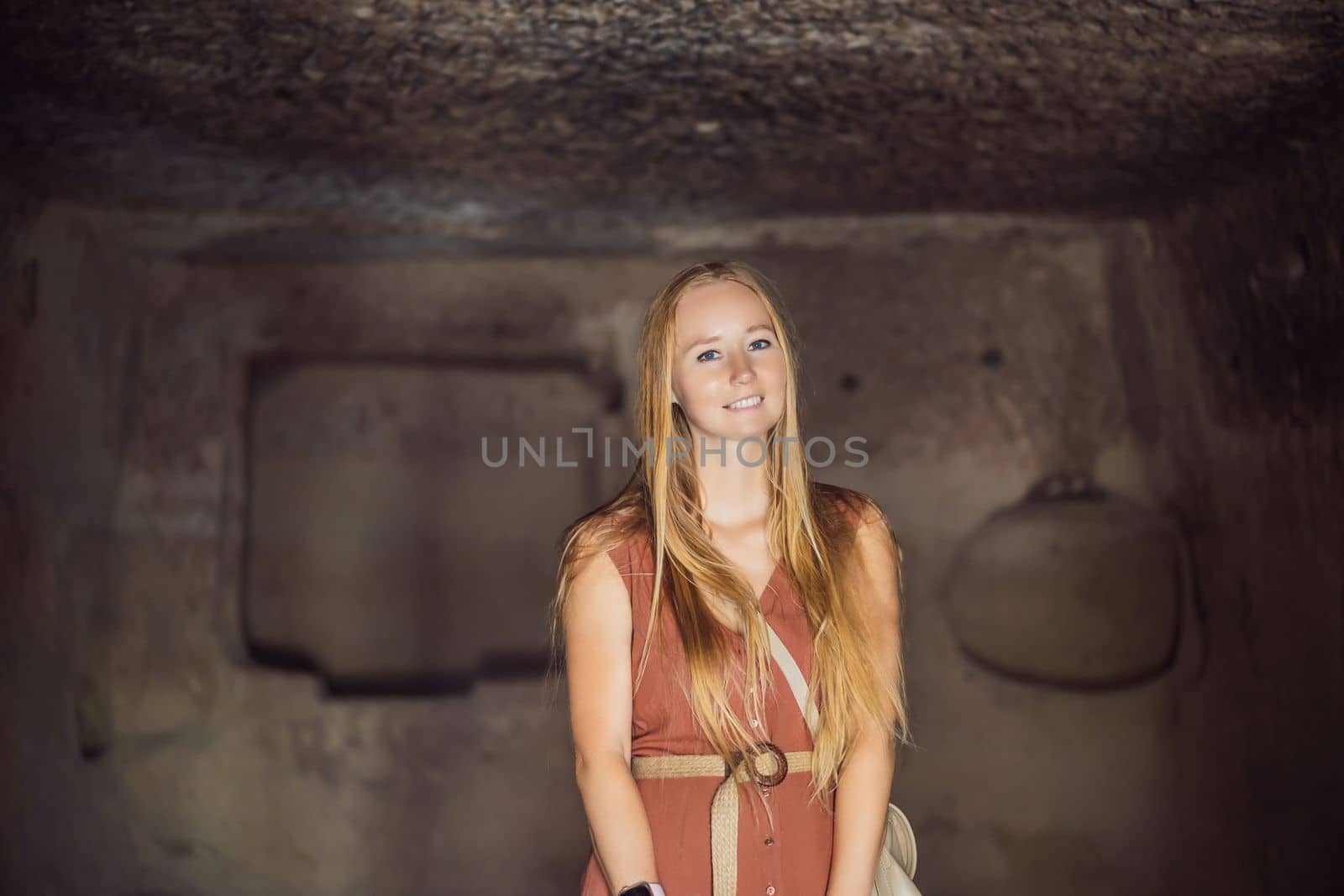 Young woman exploring valley with rock formations and fairy caves near Goreme in Cappadocia Turkey.