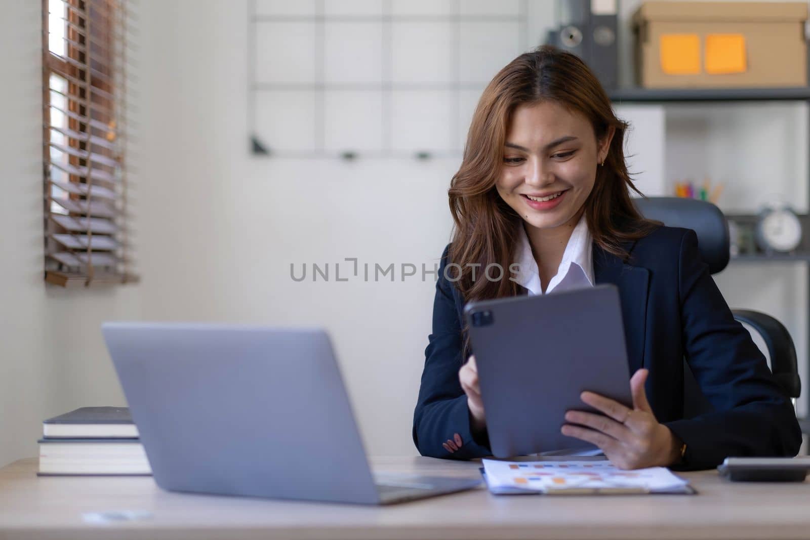 Beautiful asian woman lawyer working and gavel, tablet, laptop in front, Advice justice and law concept. by wichayada