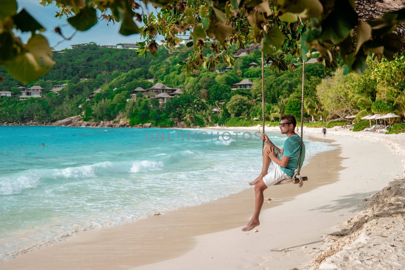 Seychelles tropical Island, Young man on the white beach during Holiday vacation Mahe Seychelles