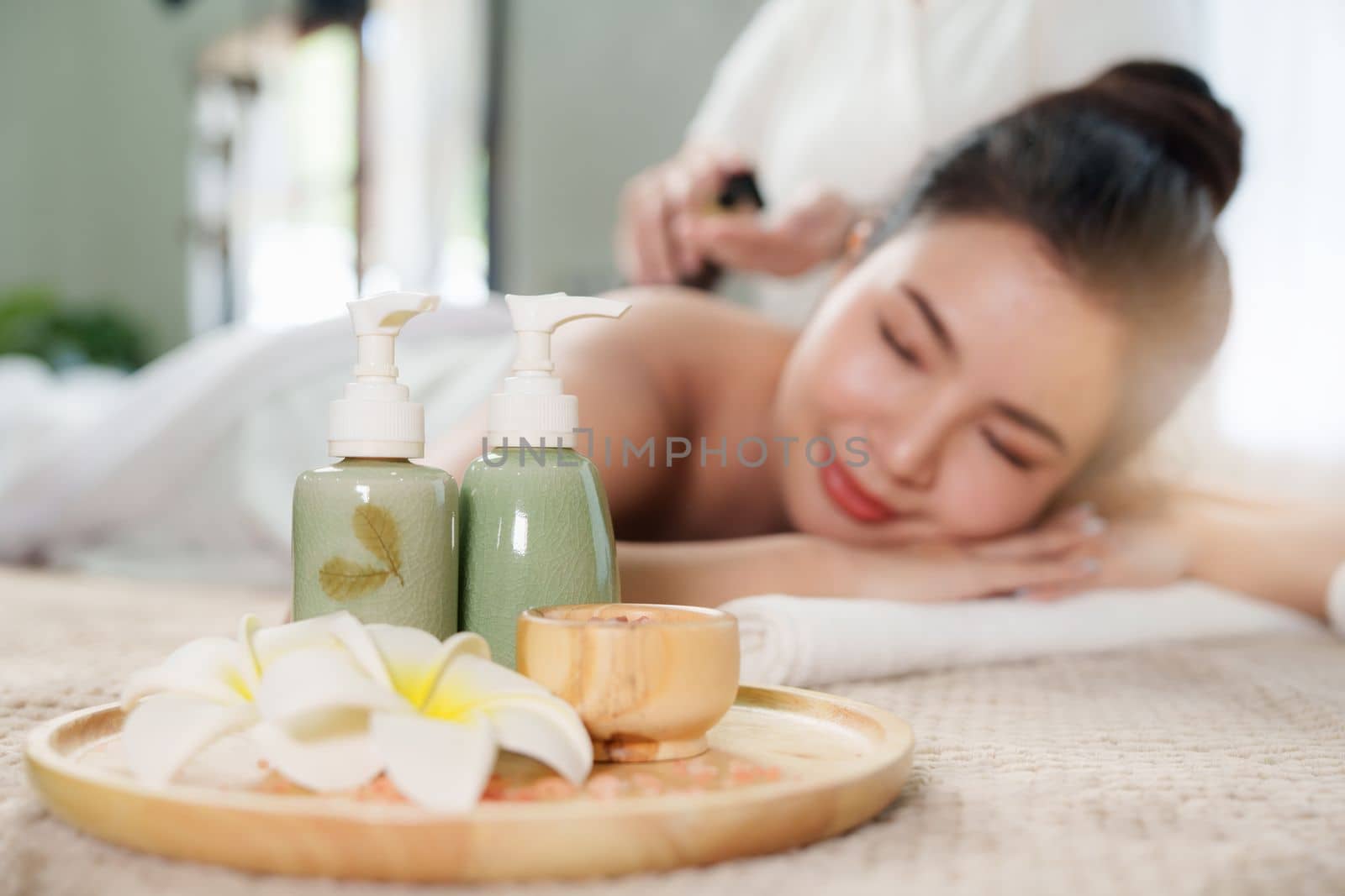 Young woman doing relaxing massage in spa salon. Female being massaged by a masseur. Spa and medicine concept by itchaznong