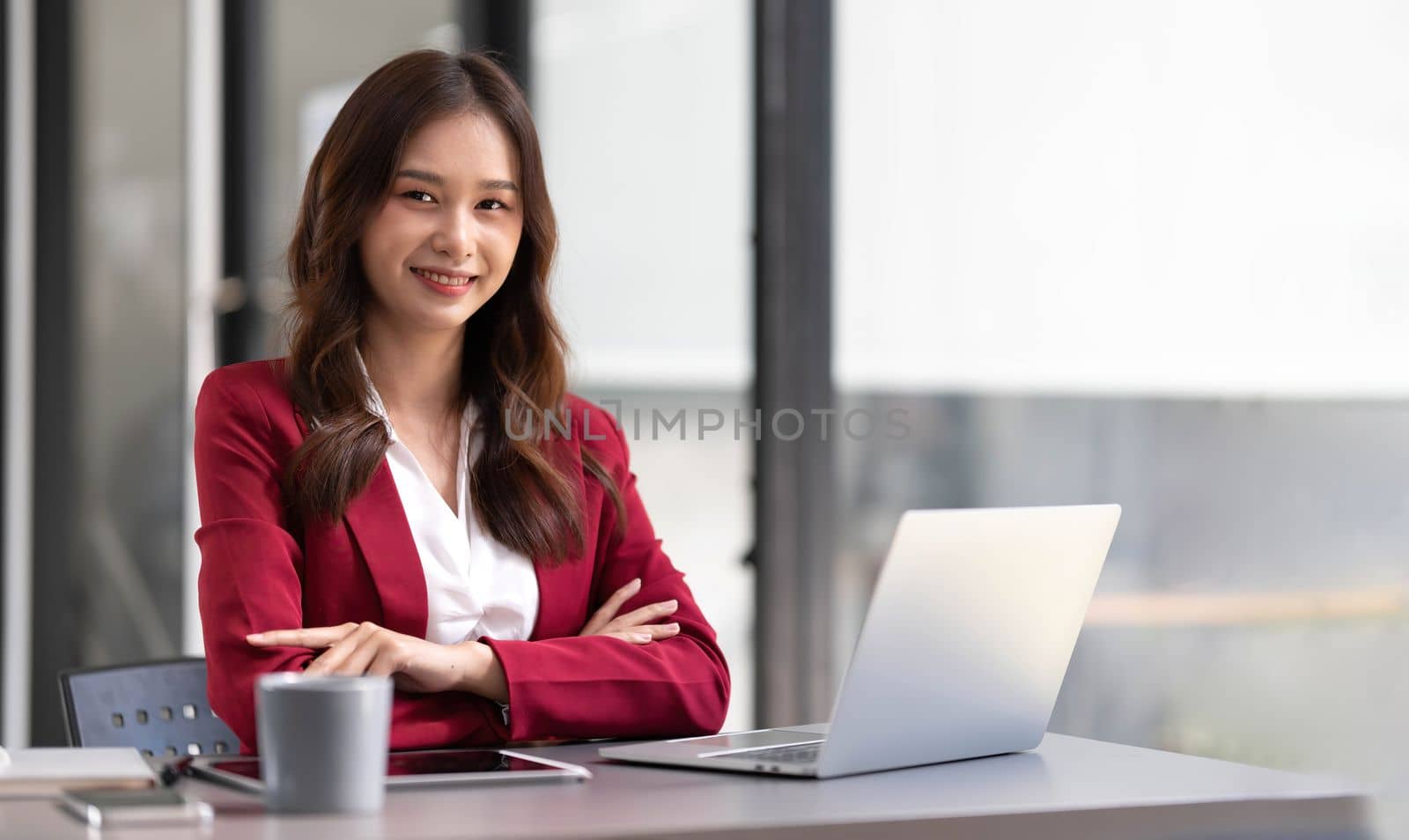 Portrait of smiling beautiful business asian woman in pink suit working in home office desk using computer. Business people employee freelance online marketing e-commerce, work from home concept by wichayada