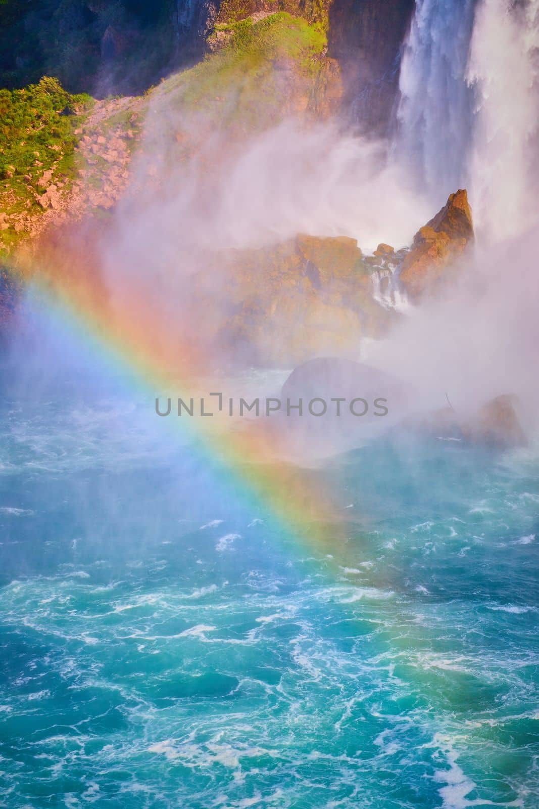 Image of Rainbow crossing through Niagara River with American Falls behind in detail