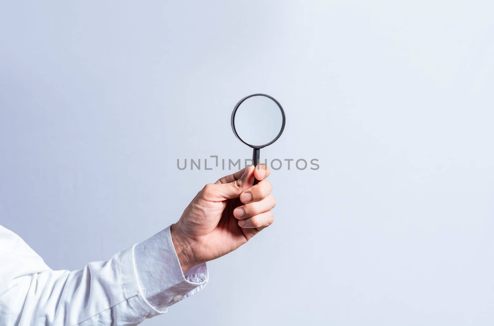 Man hand holding magnifying glass on white background. Hand holding magnifying glass looking for something with space for text, Hand holding magnifying glass on isolated background