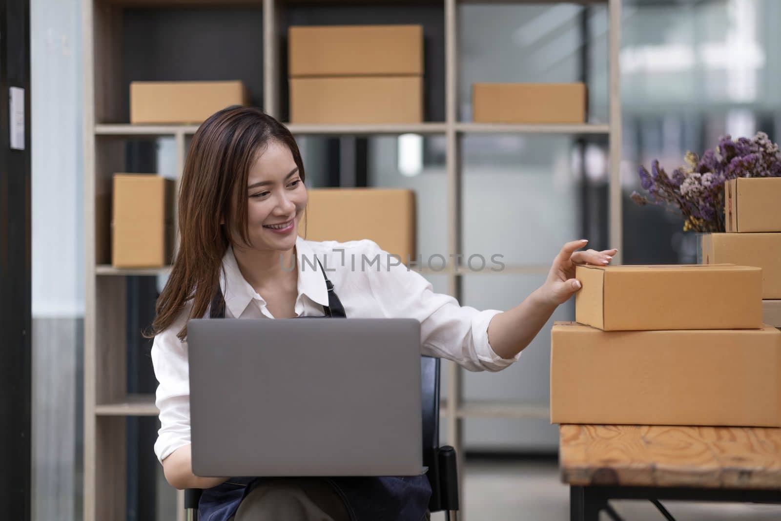 A portrait of a small startup, an SME owner, an Asian female entrepreneur checking orders to arrange the produce before packing the products in the inner boxes with the customers. Freelance concepts..