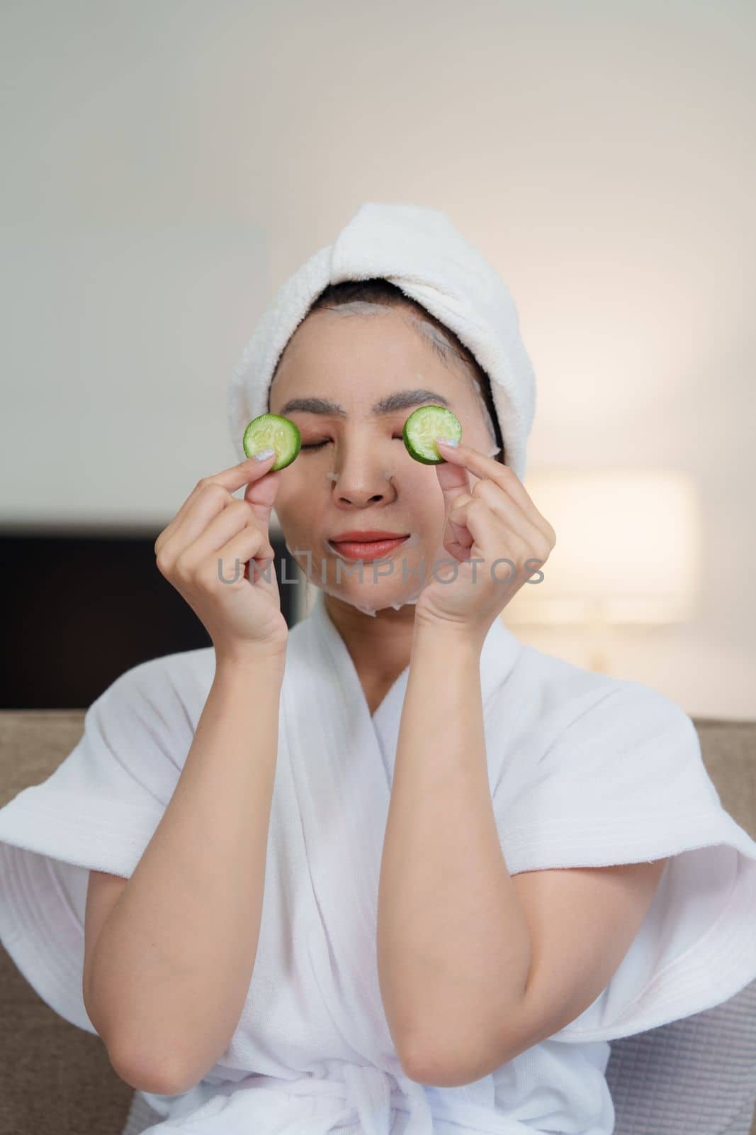 Woman with facial mask at home. Skin care, face treatment, spa, cosmetology and natural beauty concept.