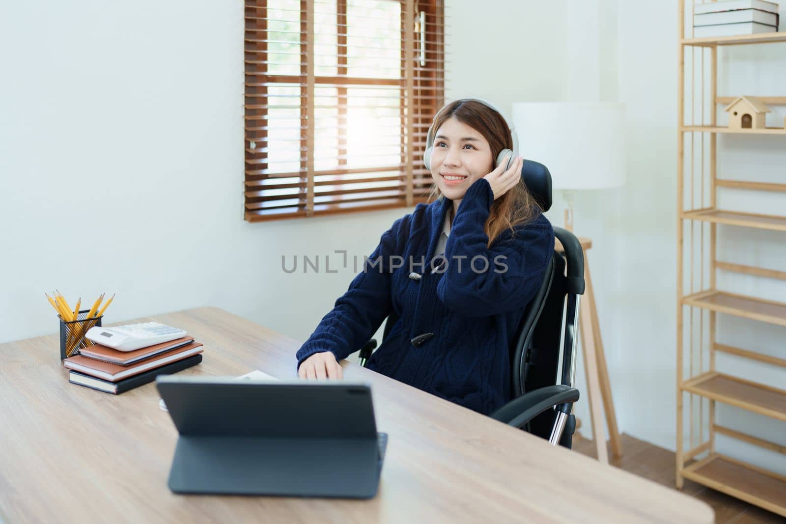 Portrait of a woman business owner showing a happy smiling face as he has successfully invested her business using computers and financial budget documents at work by Manastrong