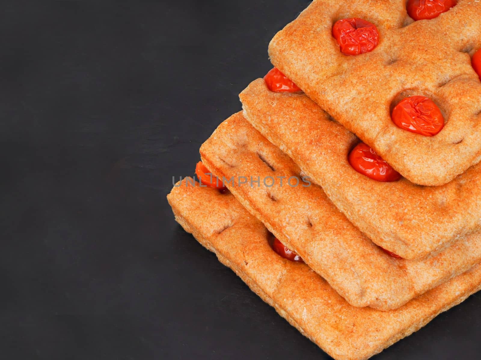 Italian flat bread organic wholewheat focaccia with tomatoes isolated in studio over a background
