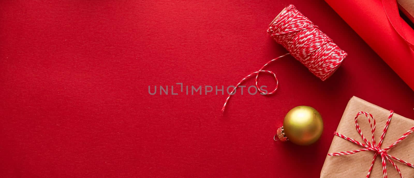 Christmas preparation, boxing day and holidays gift giving, xmas craft paper and ribbons for gifts boxes on red background as wrapping tools and decorations, diy presents as holiday flat lay design