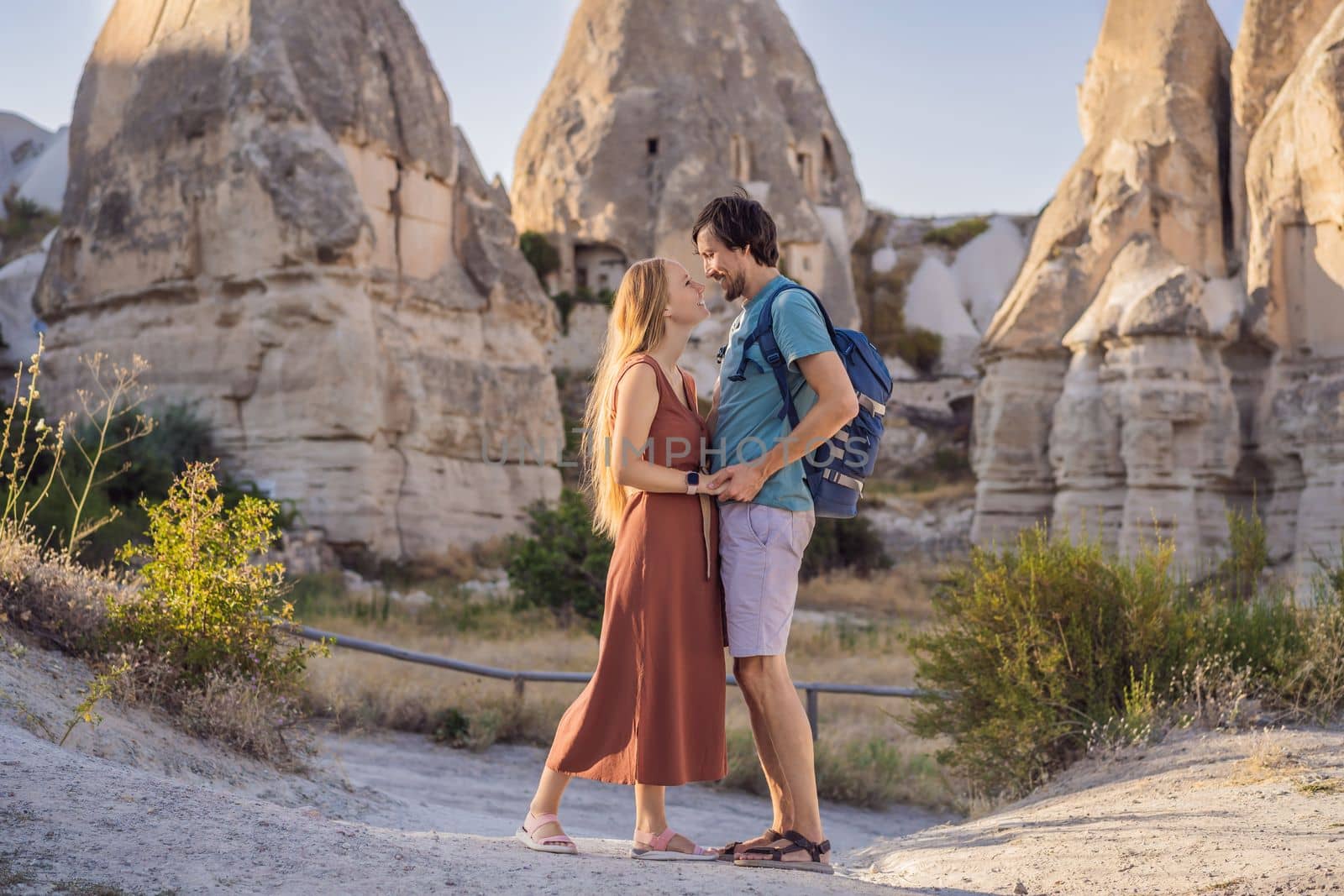 Happy couple tourists on background of Unique geological formations in Love Valley in Cappadocia, popular travel destination in Turkey by galitskaya