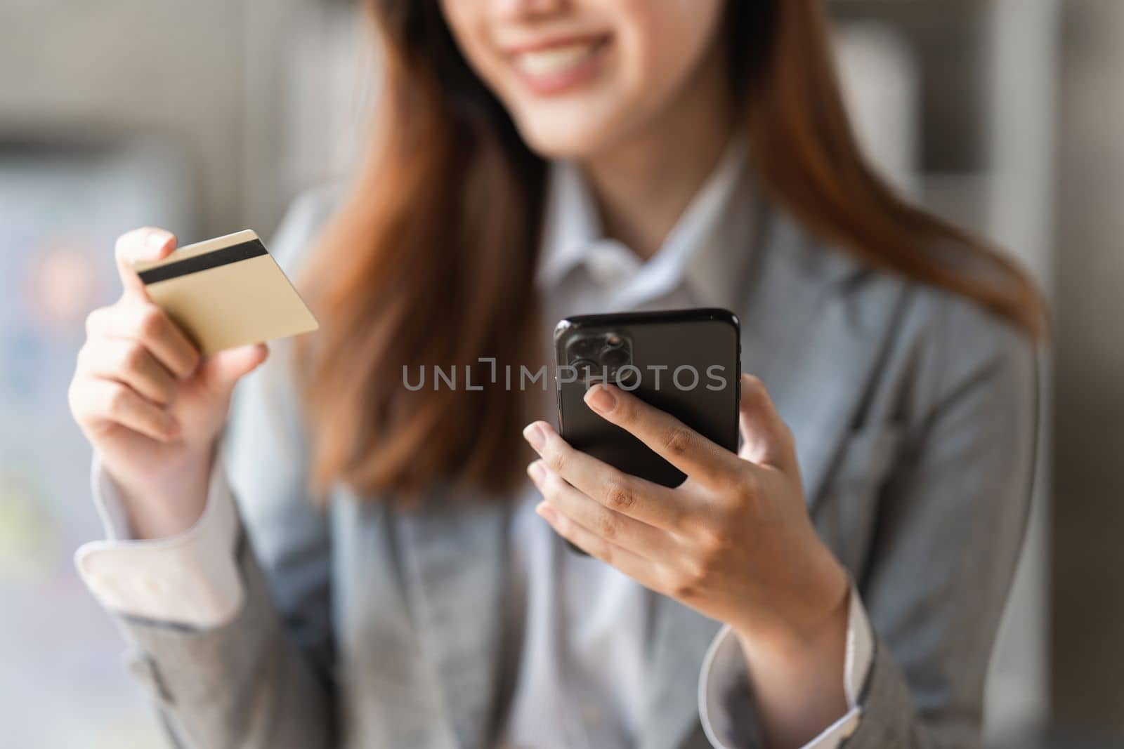 Young person using credit card and mobile phone. Online shopping, e-commerce concept.