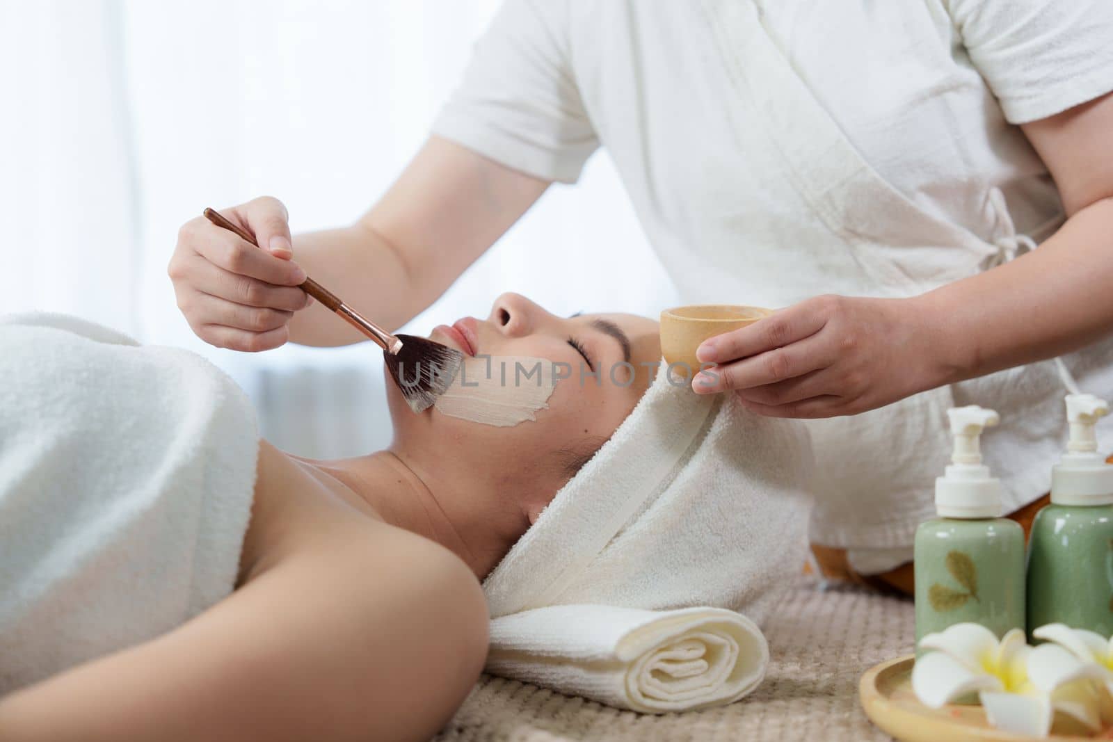 Young woman doing relaxing massage in spa salon. Female being massaged by a masseur. Spa and medicine concept by itchaznong