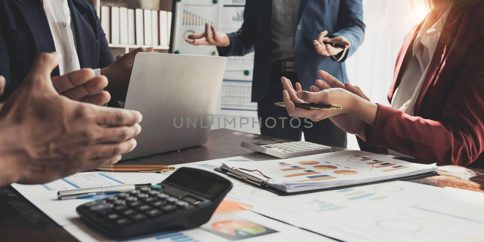 Business People Meeting using laptop computer,calculator,notebook,stock market chart paper for analysis Plans to improve quality next month. Conference Discussion Corporate Concept