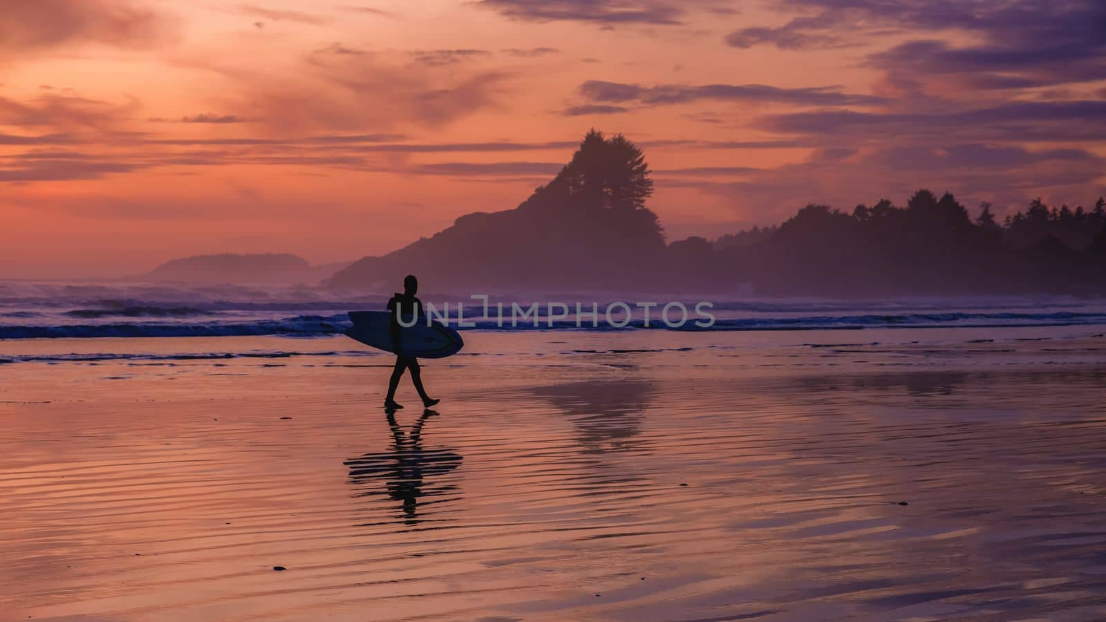 Tofino Vancouver Island Pacific rim coast, surfers with board during sunset at the beach by fokkebok