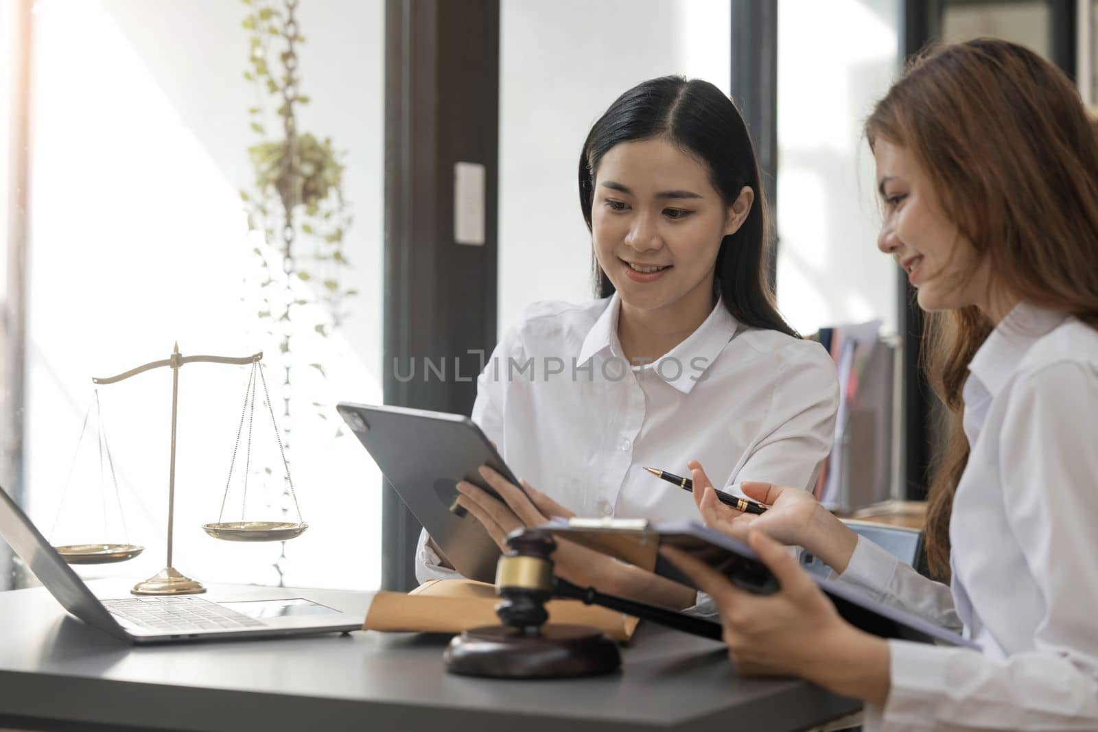 Business law concept, Lawyer business lawyers are consulting lawyers for women entrepreneurs to file copyright lawsuit with laptop and tablet..