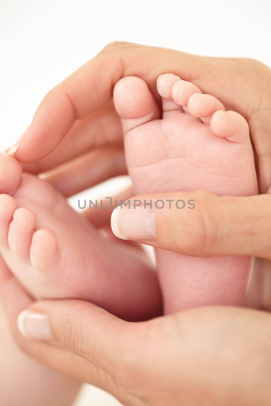 Cradling tiny feet. Cropped close up shot of a mother holding her babies feet