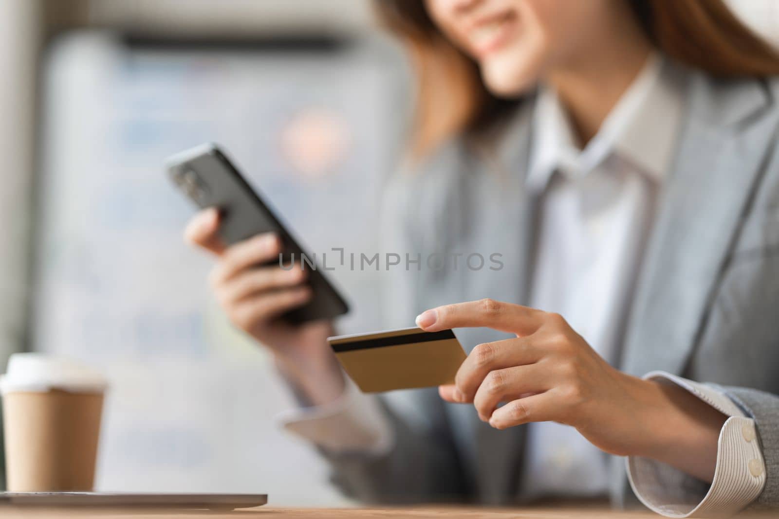 Young person using credit card and mobile phone. Online shopping, e-commerce concept.