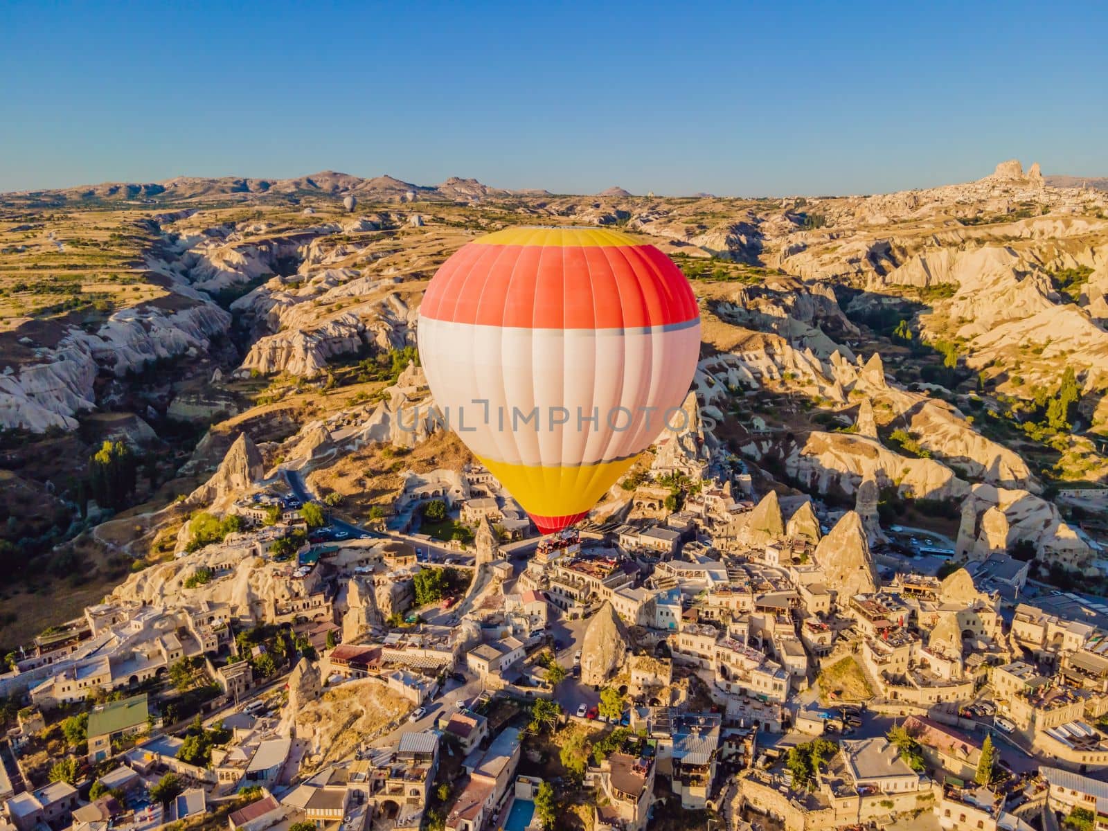 Colorful hot air balloons flying over at fairy chimneys valley in Nevsehir, Goreme, Cappadocia Turkey. Spectacular panoramic drone view of the underground city and ballooning tourism. High quality by galitskaya