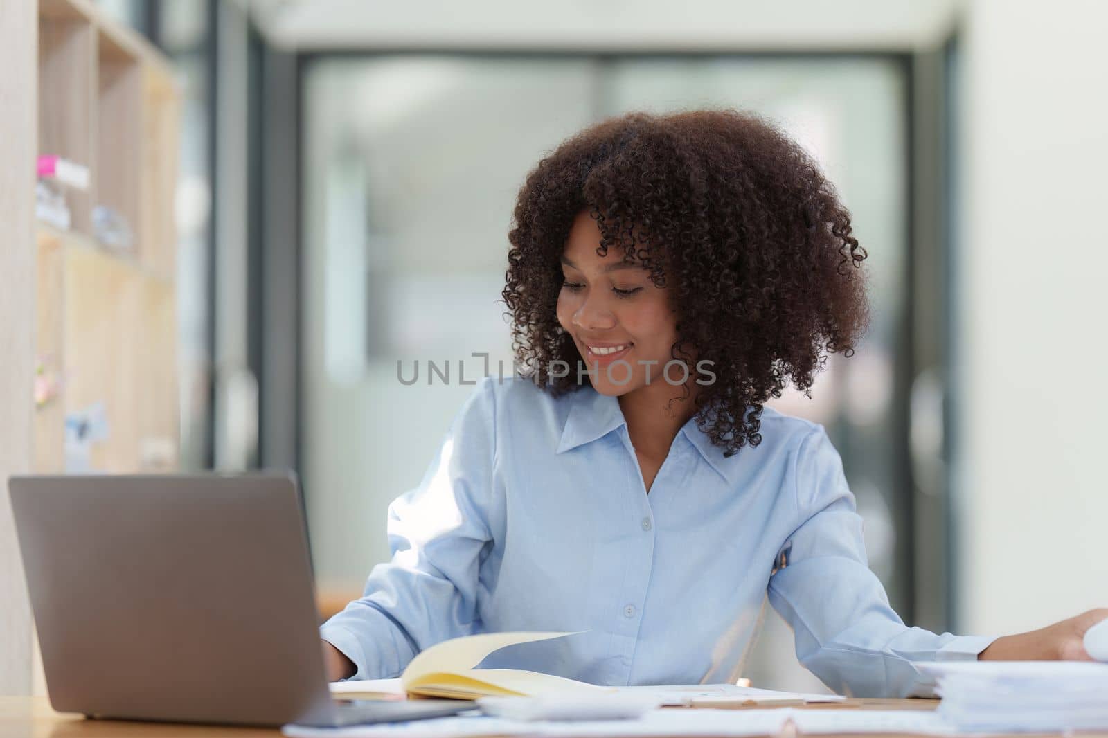 Young African American businesswoman working by laptop at office, Focus at screen laptop, reading interesting article online and finance.