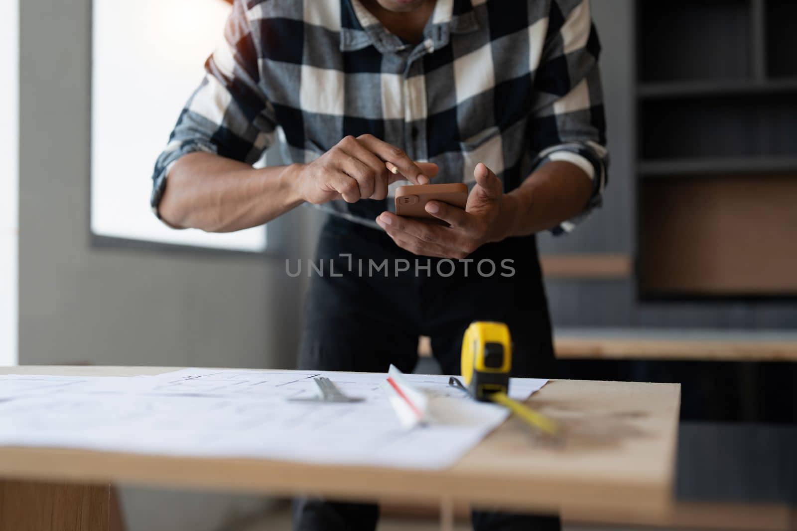 Architect man working with blueprints for architectural plan, engineer sketching a construction project, green energy concept.