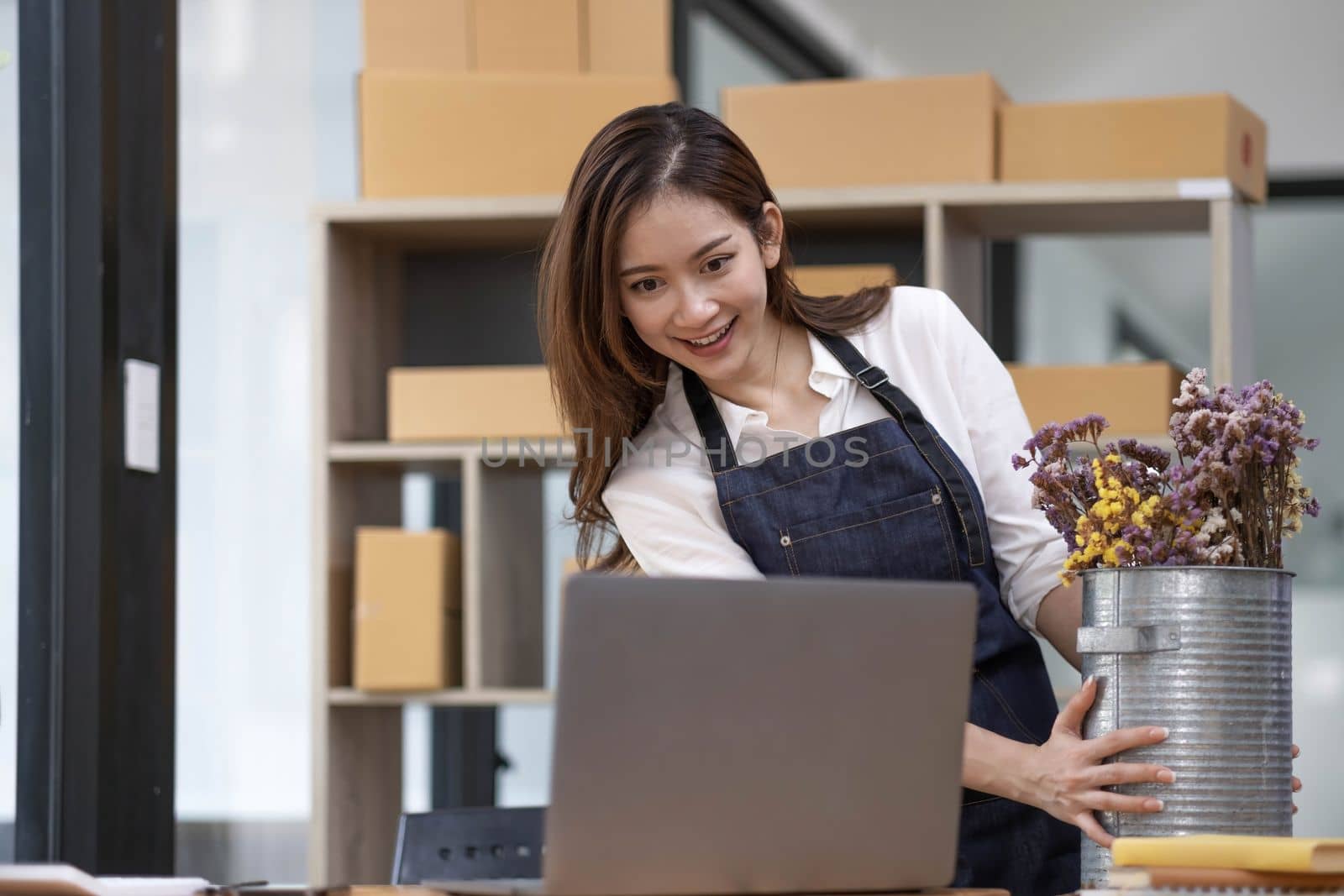 A portrait of a small startup, an SME owner, an Asian female entrepreneur checking orders to arrange the produce before packing the products in the inner boxes with the customers. Freelance concepts..