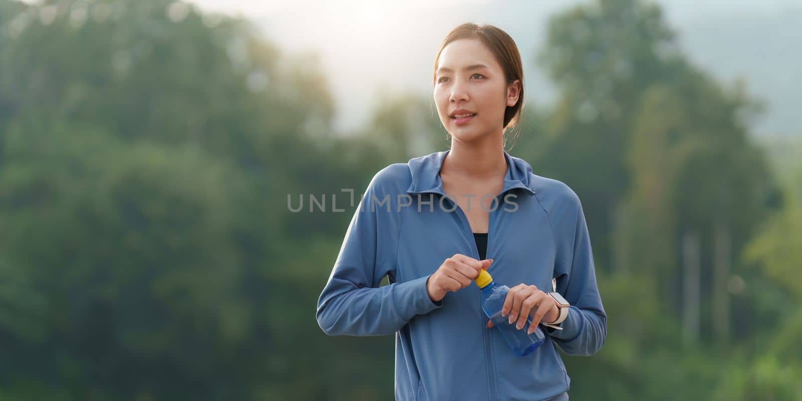 Healthy Asian woman is jogging outdoor. Fitness girl running. Female exercising at outdoor park.