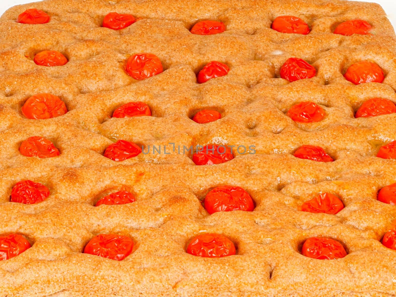 Italian flat bread organic wholewheat focaccia with tomatoes isolated in studio over a background