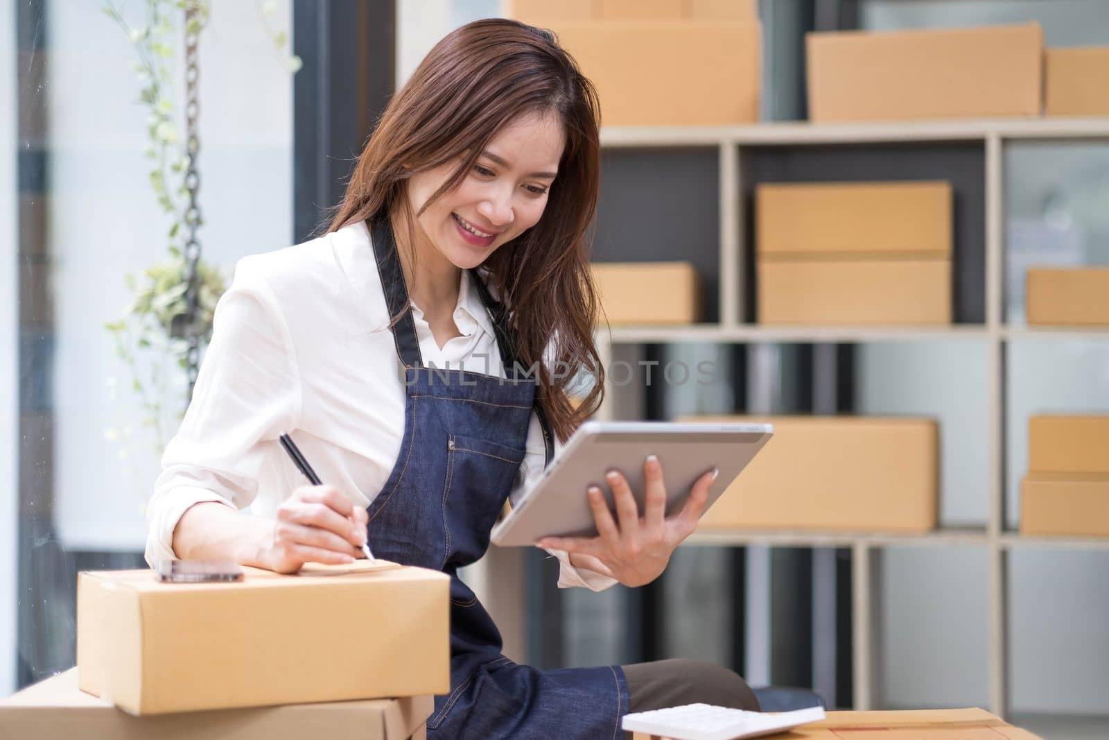 Successful entrepreneur business woman with online sales and Parcel shipping in her home office, prepare parcel box of product for deliver to customer...