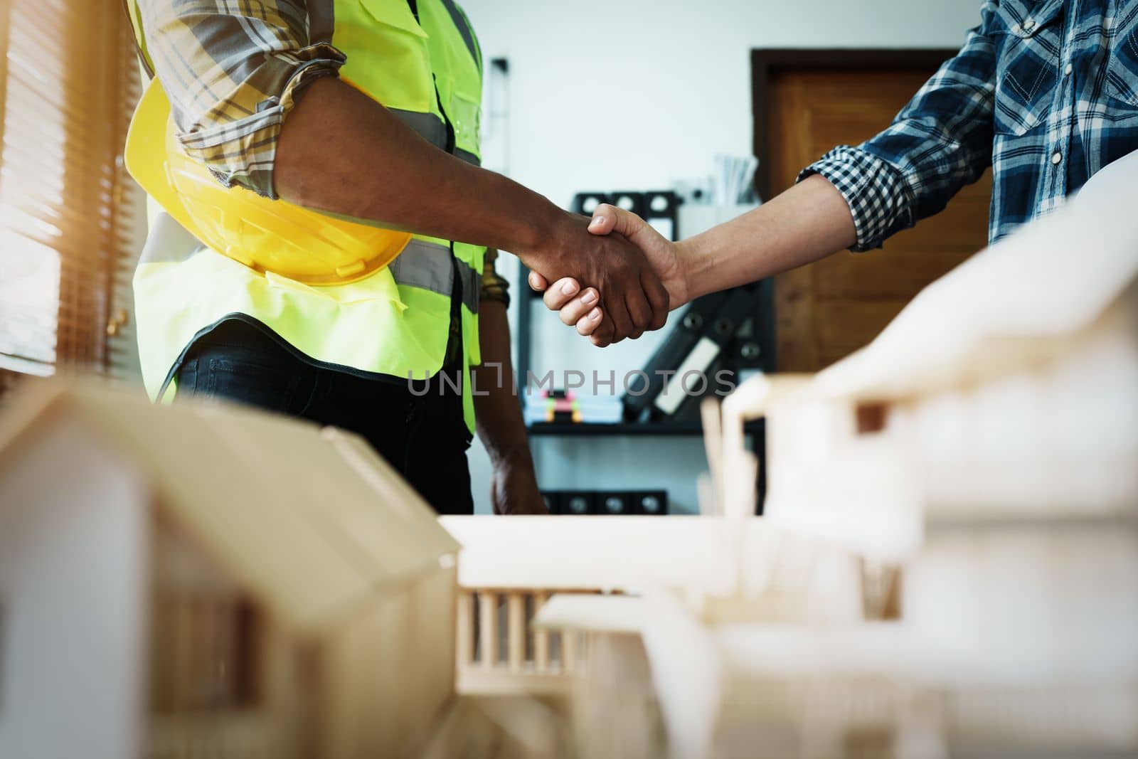 Engineers shaking hands to congratulate after success To create a building architecture successfully according to the goals that have been set.