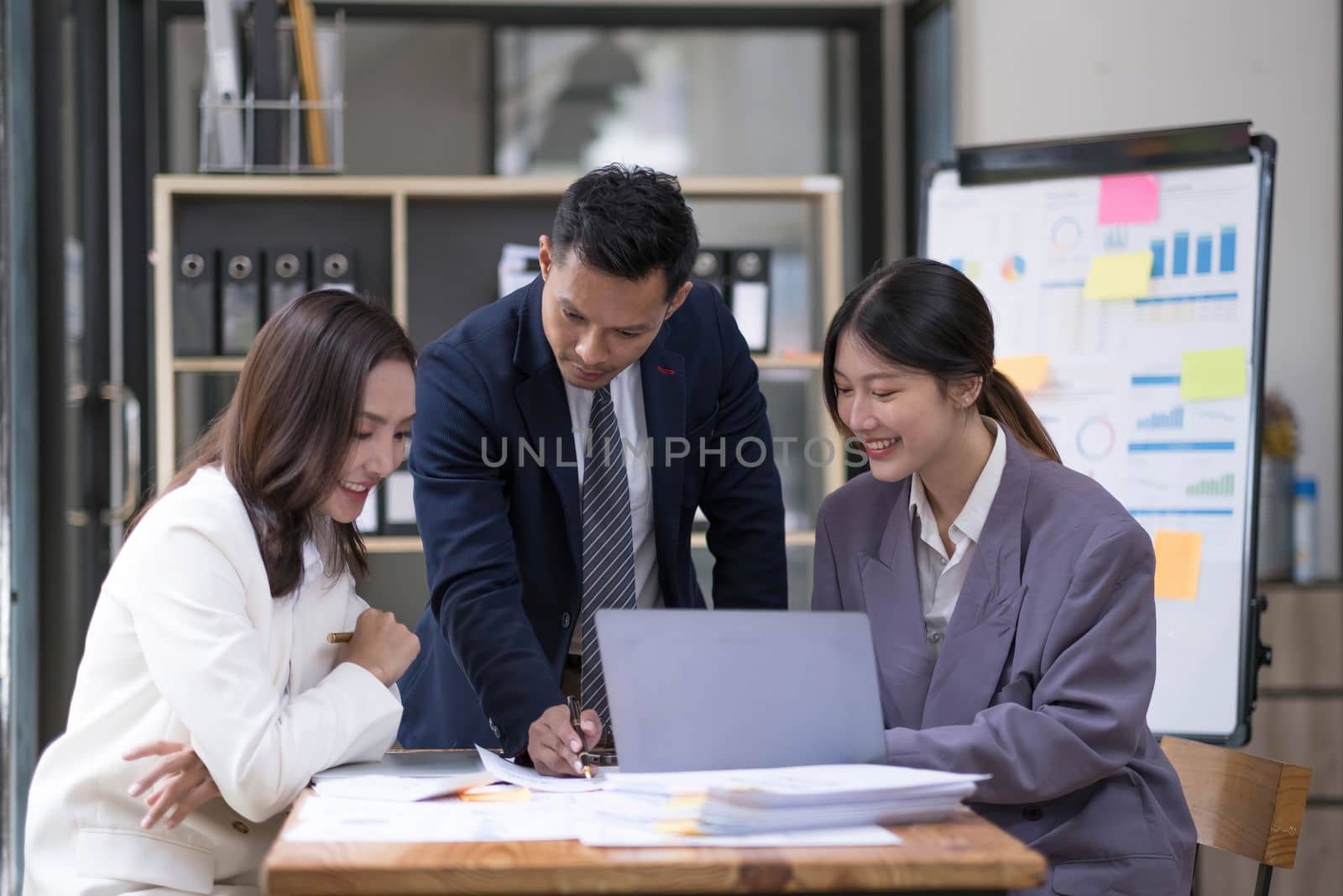 Group of young asian modern people in smart casual wear having a brainstorm meeting. Group of young asian business people discussing in the meeting. by wichayada