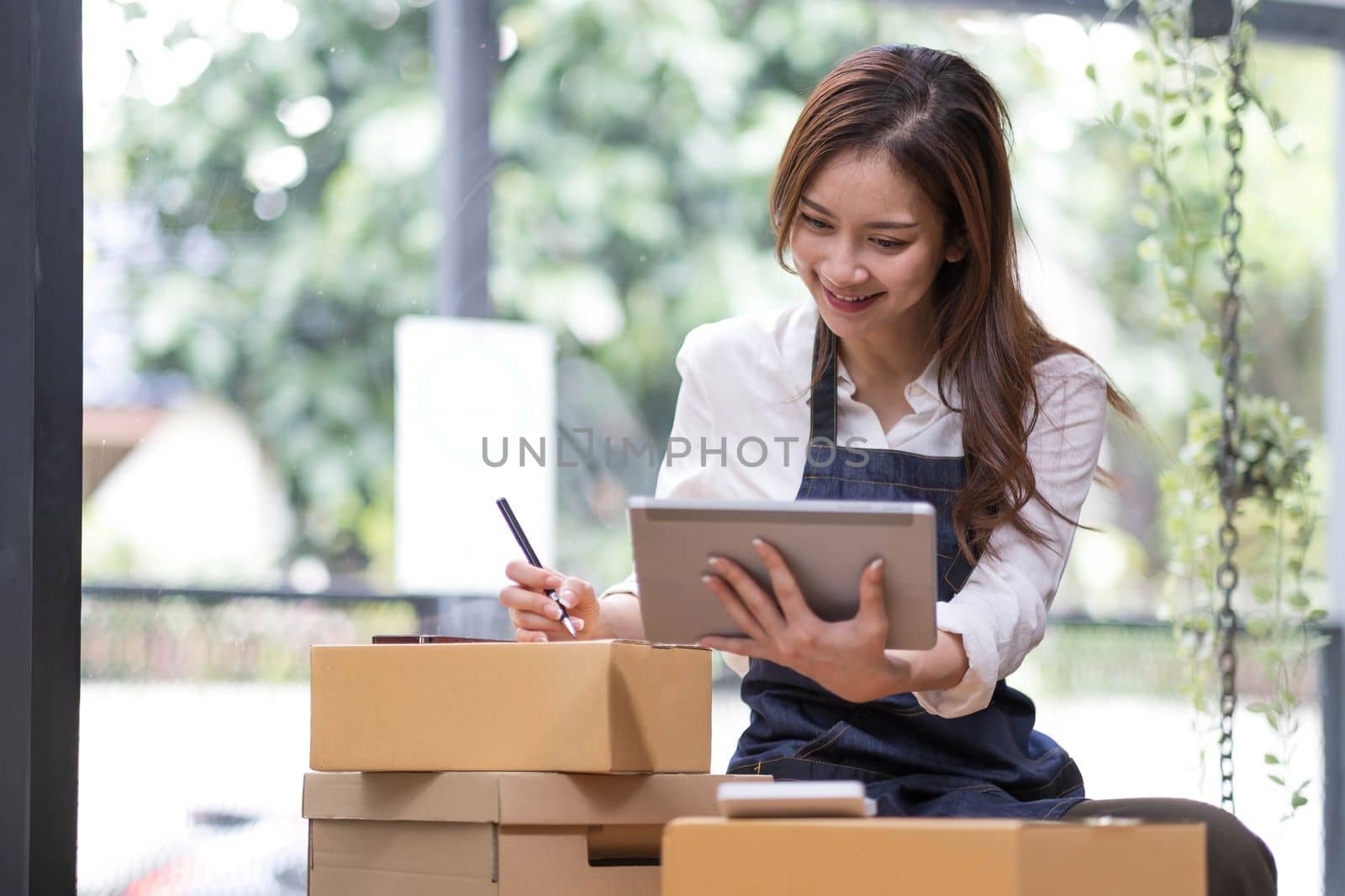 Successful entrepreneur business woman with online sales and Parcel shipping in her home office, prepare parcel box of product for deliver to customer...
