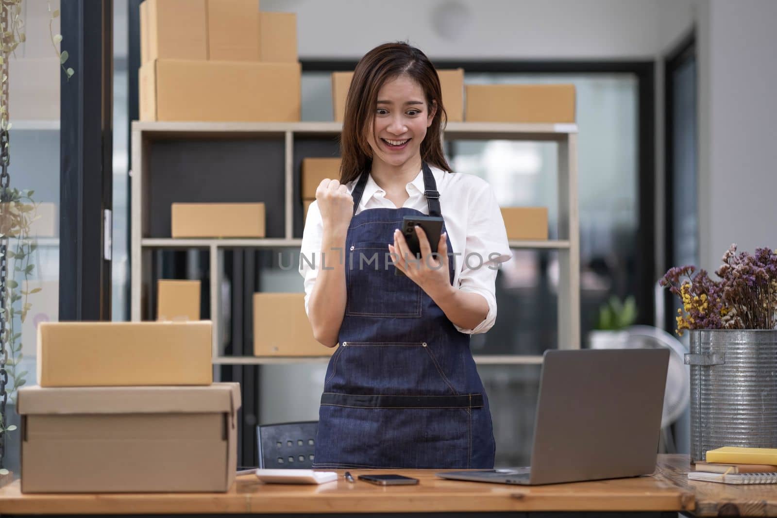 Entrepreneur of beautiful business asian young woman working online with laptop and celebrating at home with her work success cheerful and happiness. Small Business Startup concept..