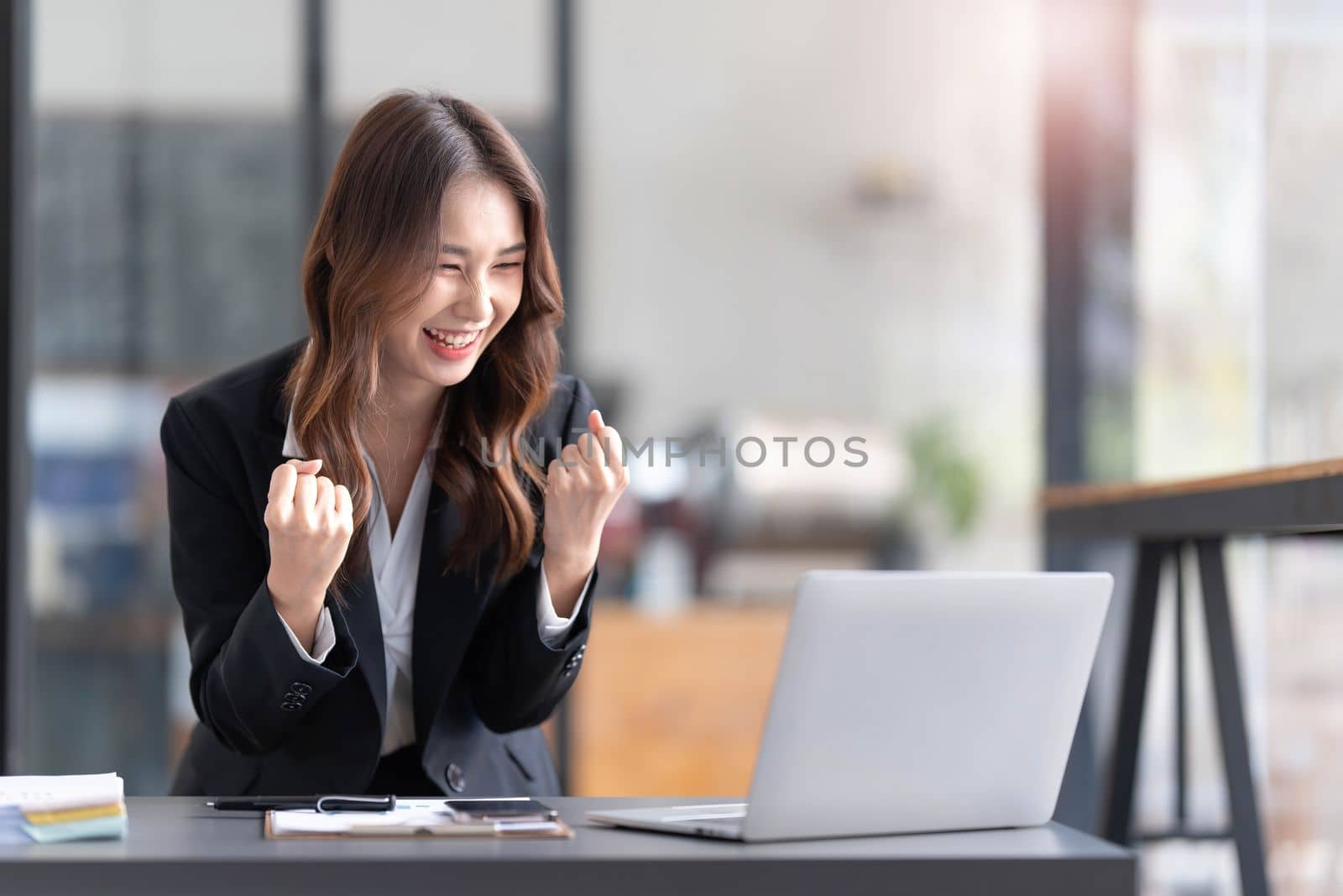 Beautiful asian woman using laptop computer, exciting and celebrating with good news of business successful. Small business startup concept...