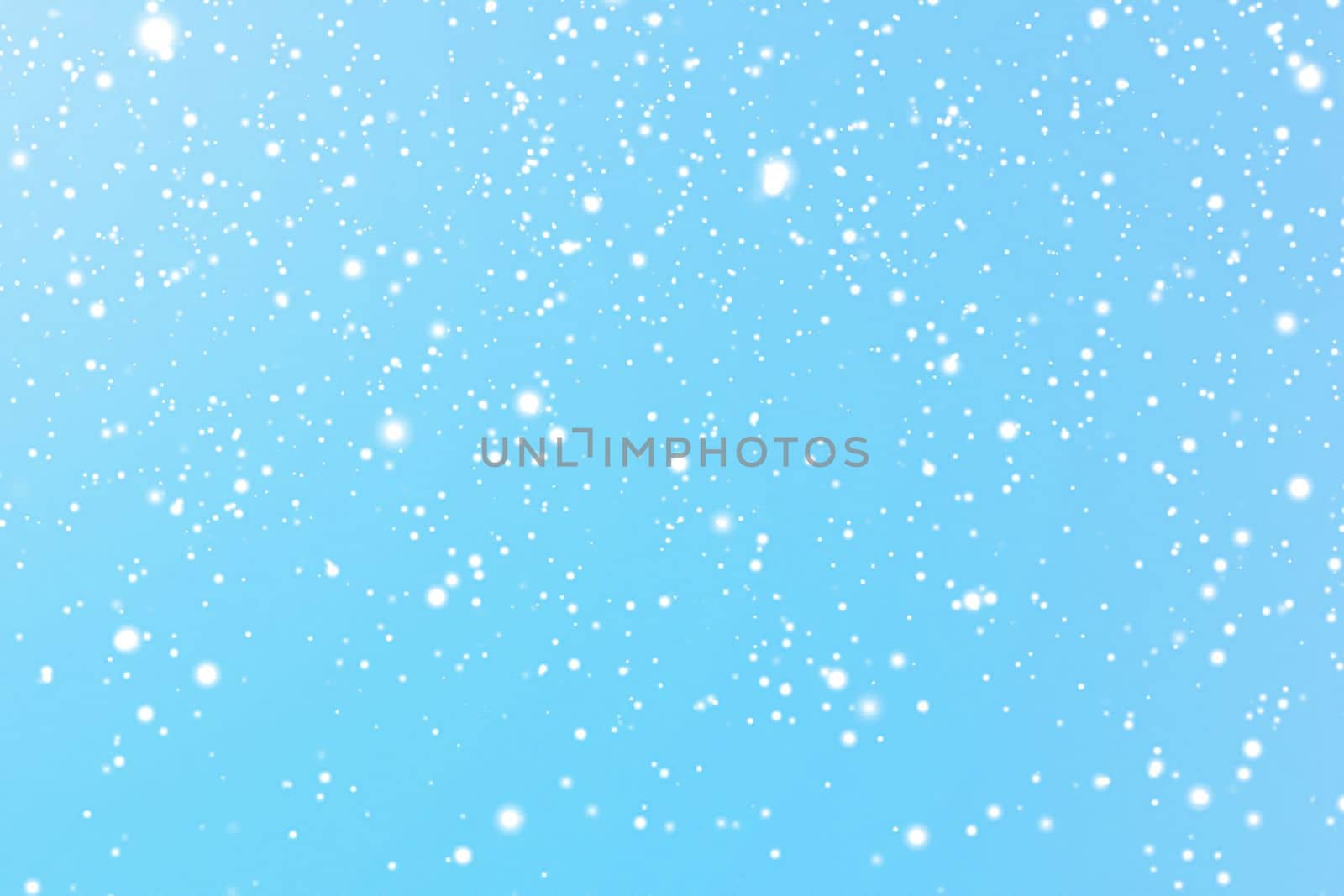 Winter holidays and wintertime background, white snow falling on blue backdrop, snowflakes bokeh and snowfall particles as abstract snowing scene for Christmas and snowy holiday design by Anneleven