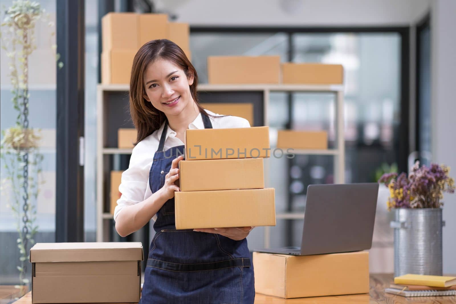 Portrait of young Asian woman working SME with a box at home the workplace.start-up small business owner, small business entrepreneur SME or freelance business online and delivery concept...