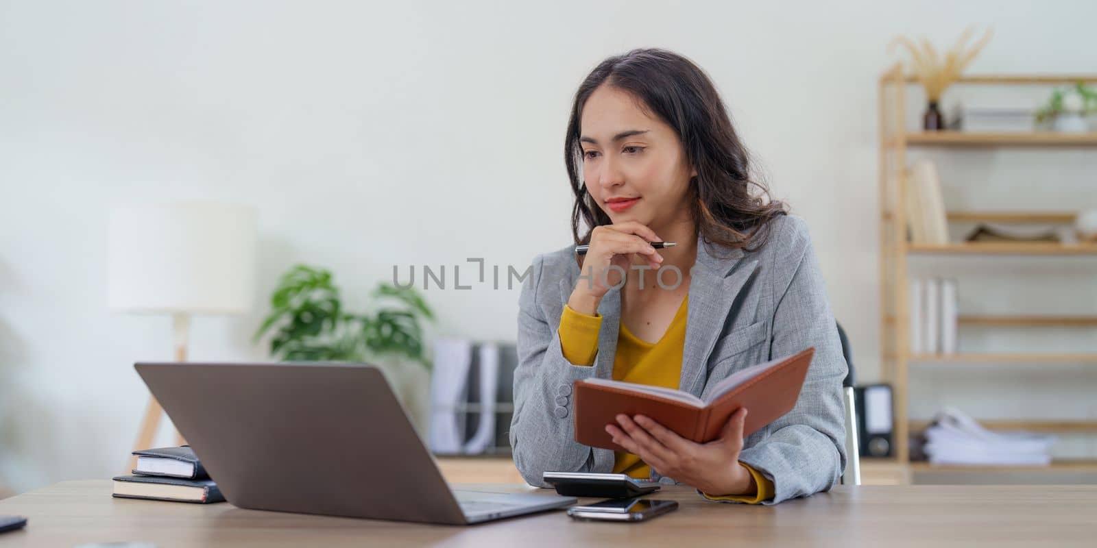 Asian Business woman working at home office and analyze financial report document. Accounting and Finance concept.