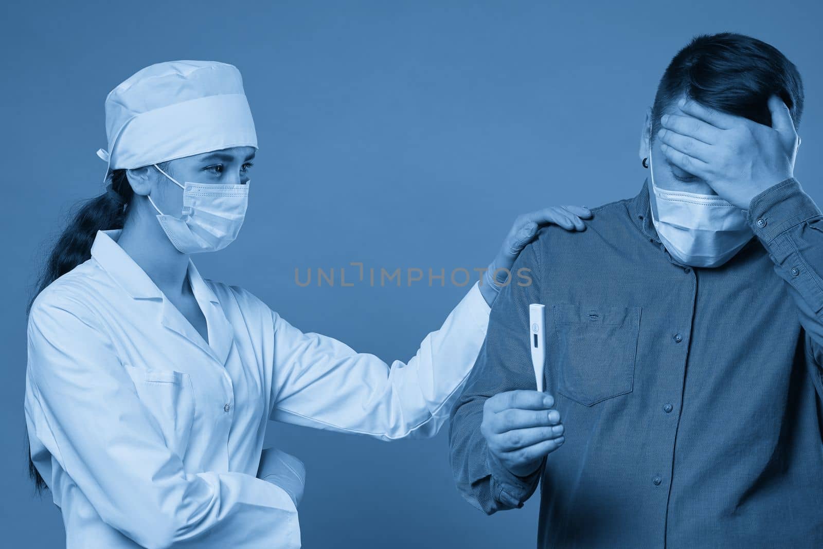 Young doctor measuring temperature of a patient with thermometer