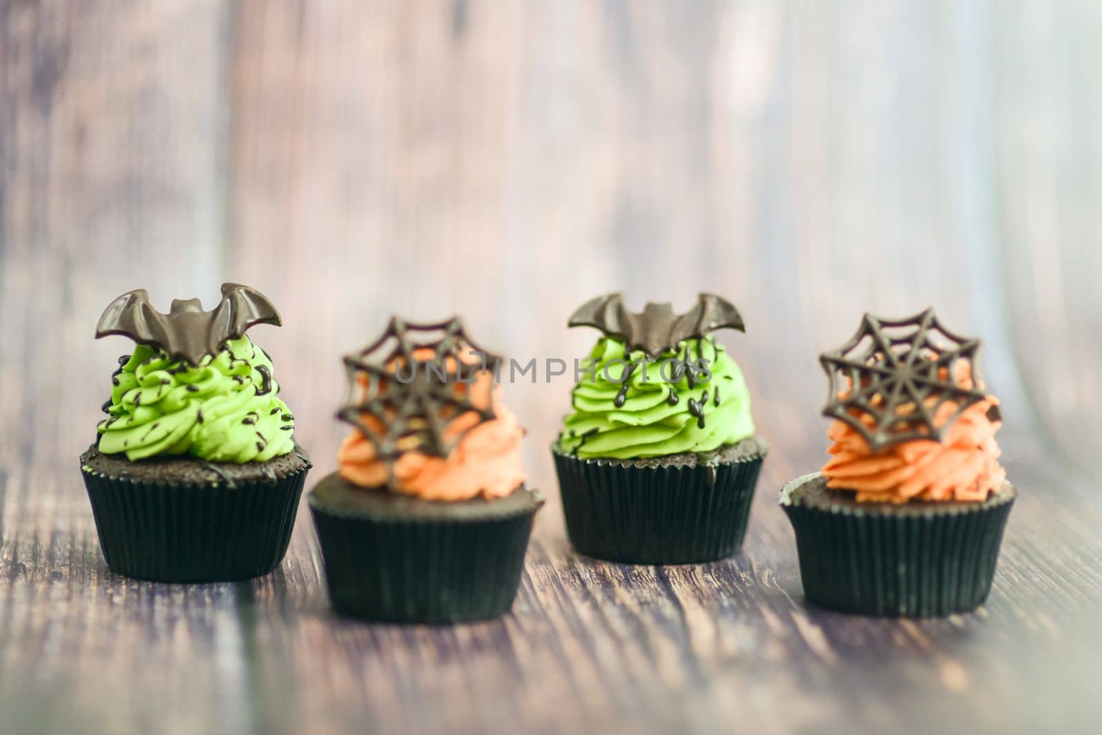 pastry chef baker preparing halloween green orange monster cupcakes handmade by verbano
