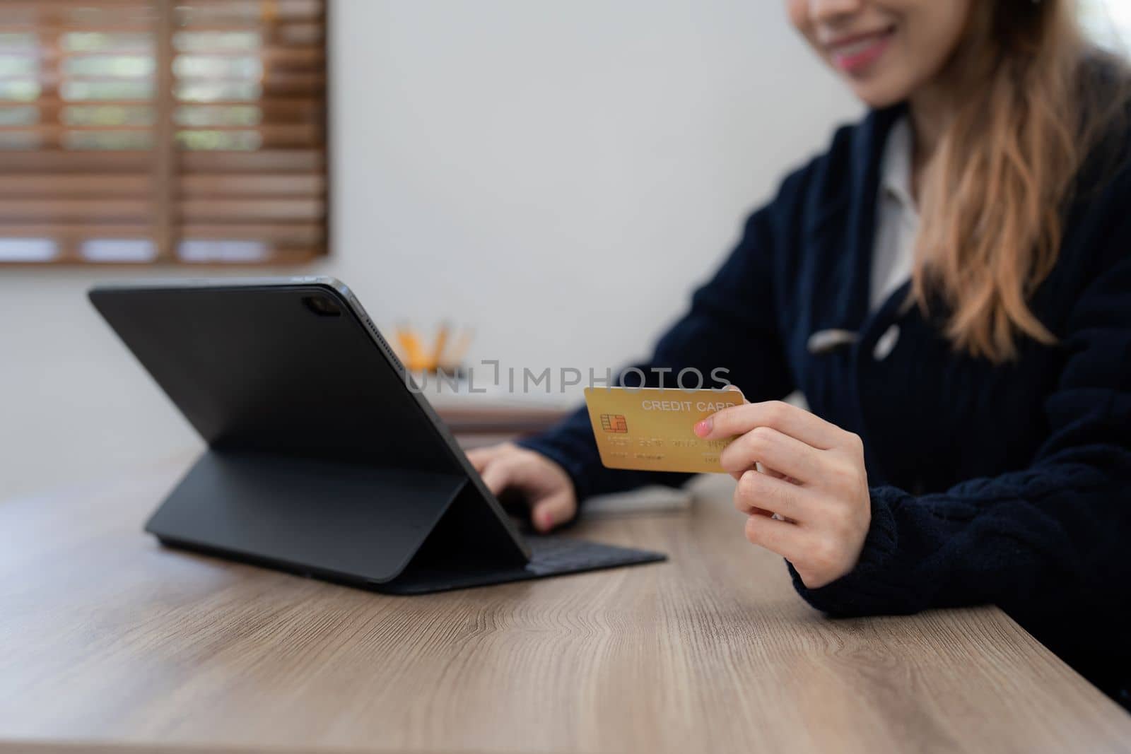 Young person using credit card and laptop computer. Online shopping, e-commerce concept.