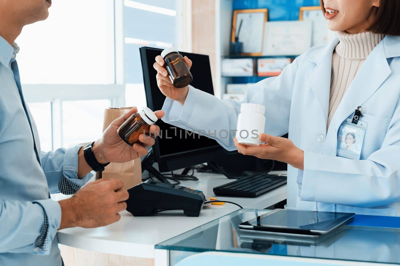 Closeup professional pharmacist advise or explain property of qualified medical product to customer in pharmacy, druggist answer to client healthcare inquiry, medical service and consultation concept.
