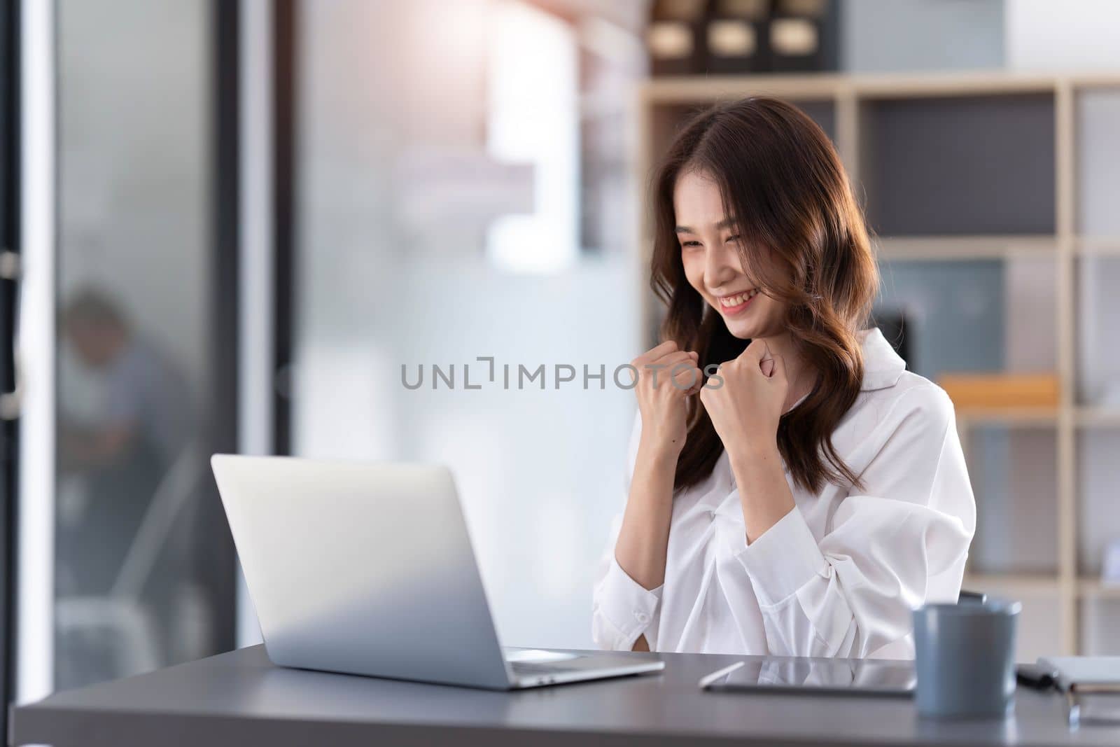 Beautiful asian woman using laptop computer, exciting and celebrating with good news of business successful. Small business startup concept...