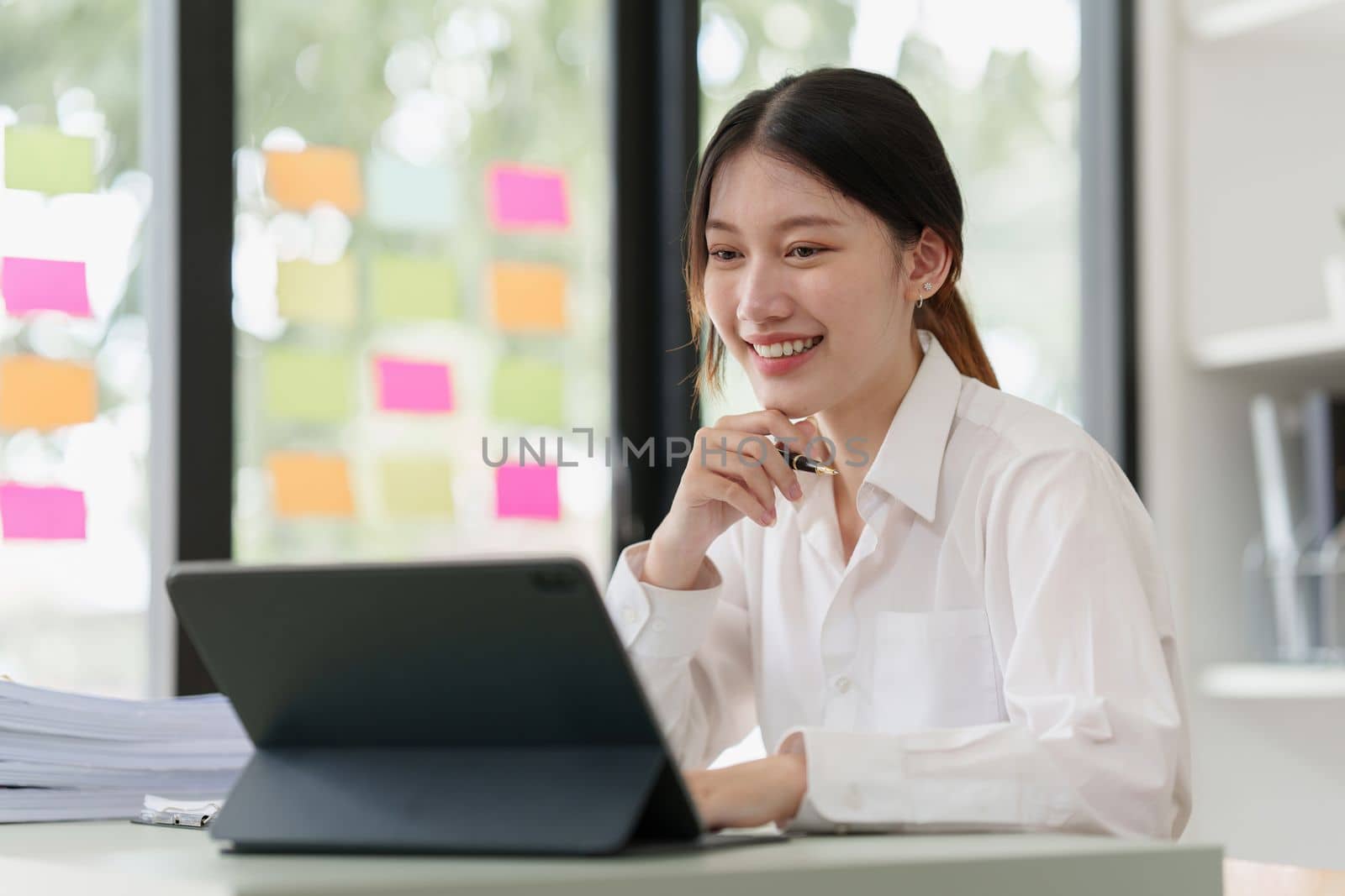 Pleasant positive business woman using digital tablet at home office.