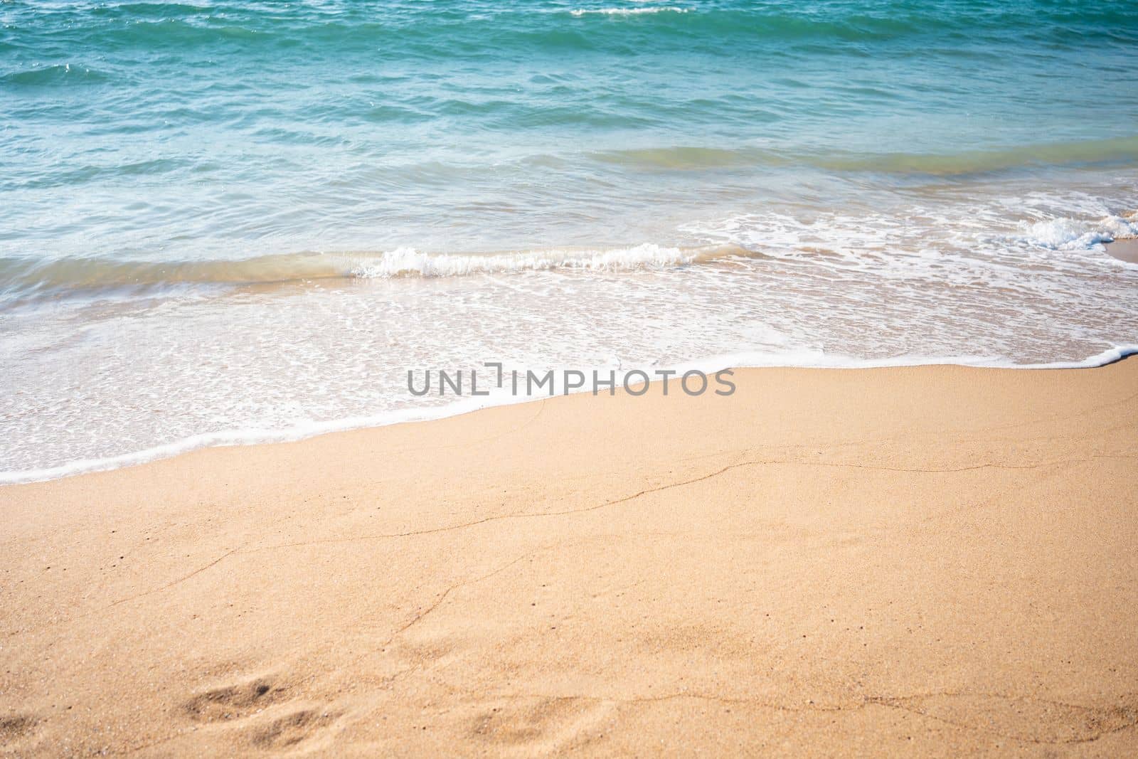 Soft beautiful ocean wave on sandy beach. Background. Turquoise color sea view with copy space
