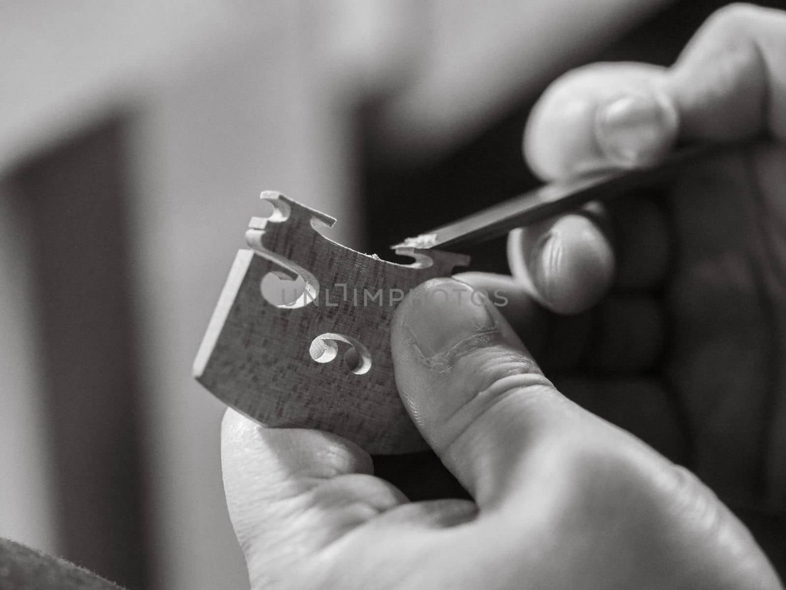 artisan shaving a bridge for precision instrument placement