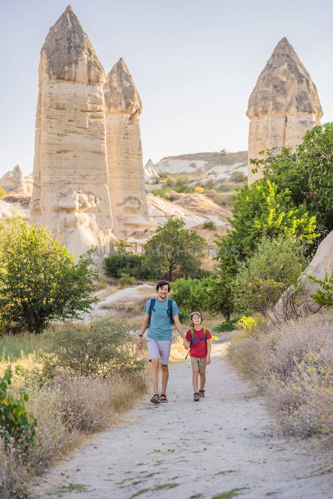 Father and son tourists on background of Unique geological formations in Love Valley in Cappadocia, popular travel destination in Turkey. Traveling with children in Turkey concept by galitskaya