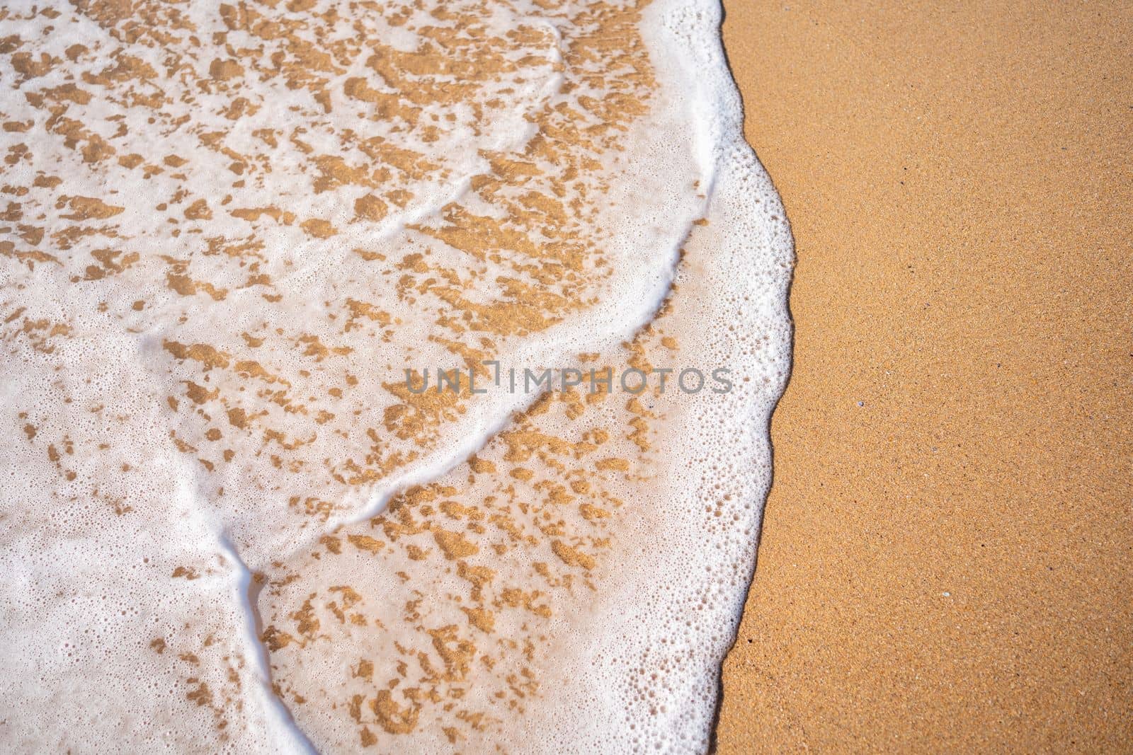 Soft beautiful ocean wave on sandy beach. Background. Turquoise color sea view with copy space