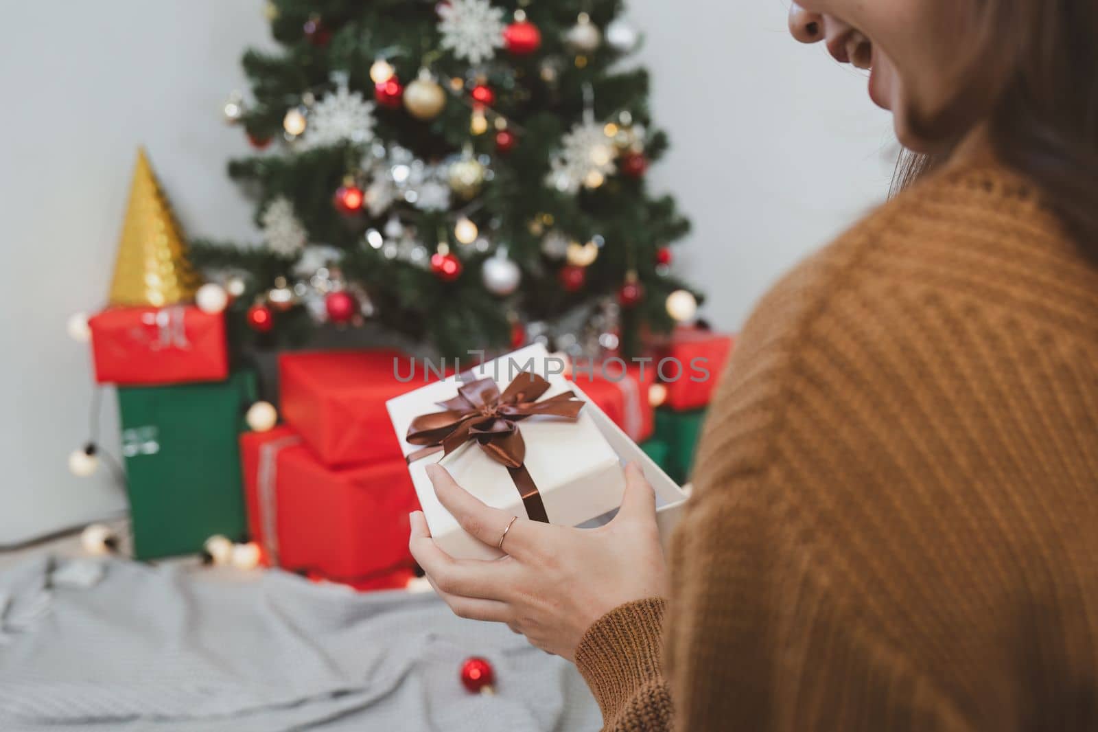 Cheerful lady surprised of the present after the opening in the gift box. Marry Christmas and Happy Holidays and New Year eve celebrating concept.